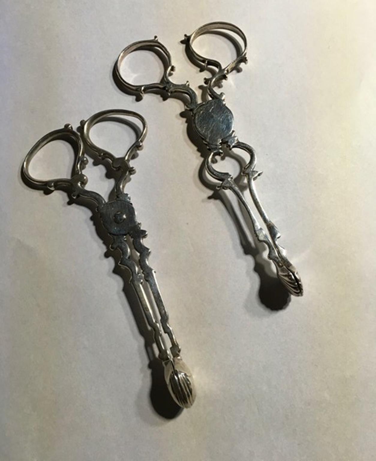 This elegant pair of antique silver nips is composed by two pieces, one is cast with shells and the other one with a little shovel shape.

Fully silver London marker.
With certificate of authenticity.