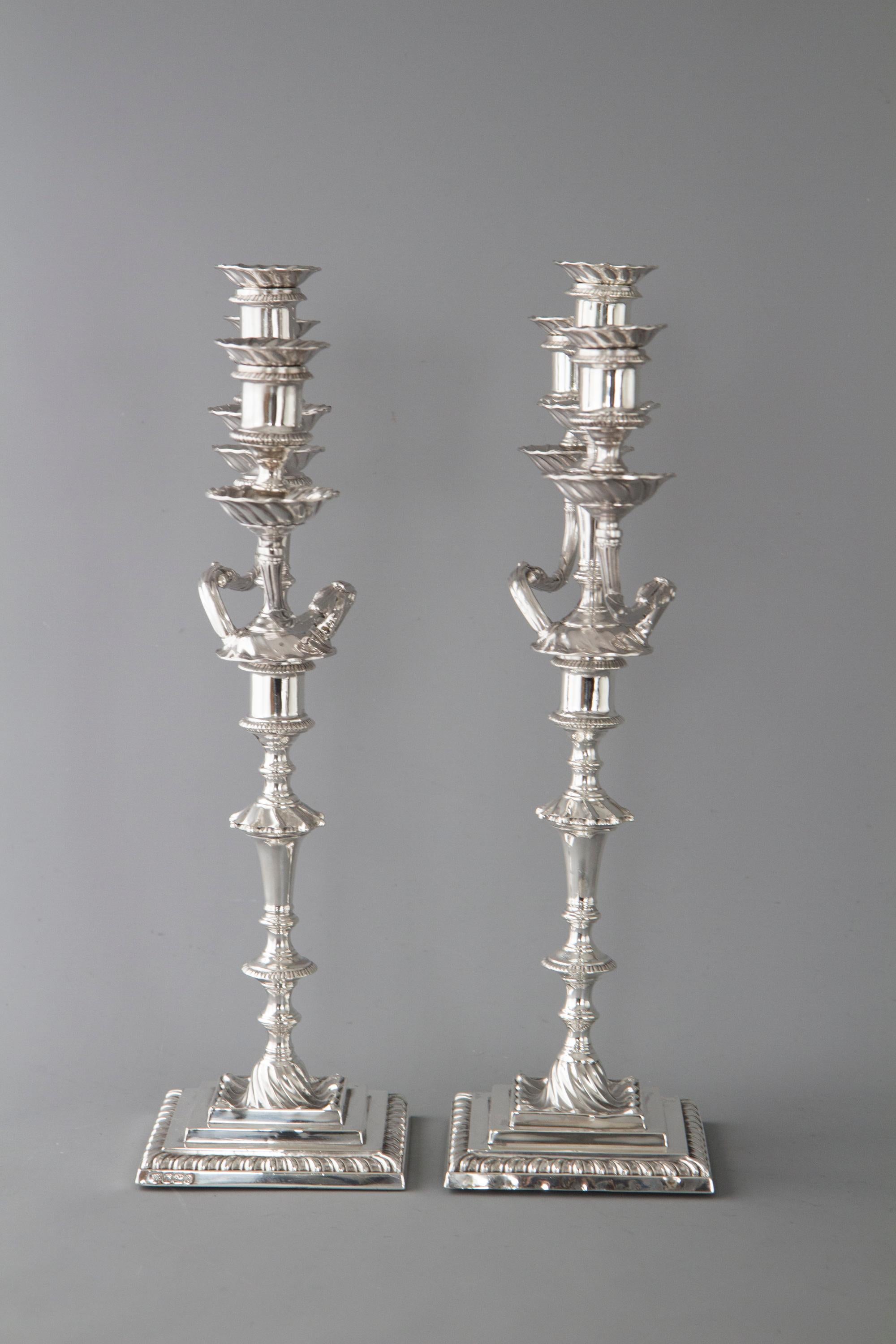 An extremely fine pair of late Victorian silver three-light candelabra. The candlesticks on stepped square section bases with spiral fluted wells. The stem with fluted tapering column, spiral knop and cotton reel capitals with fluted borders. The