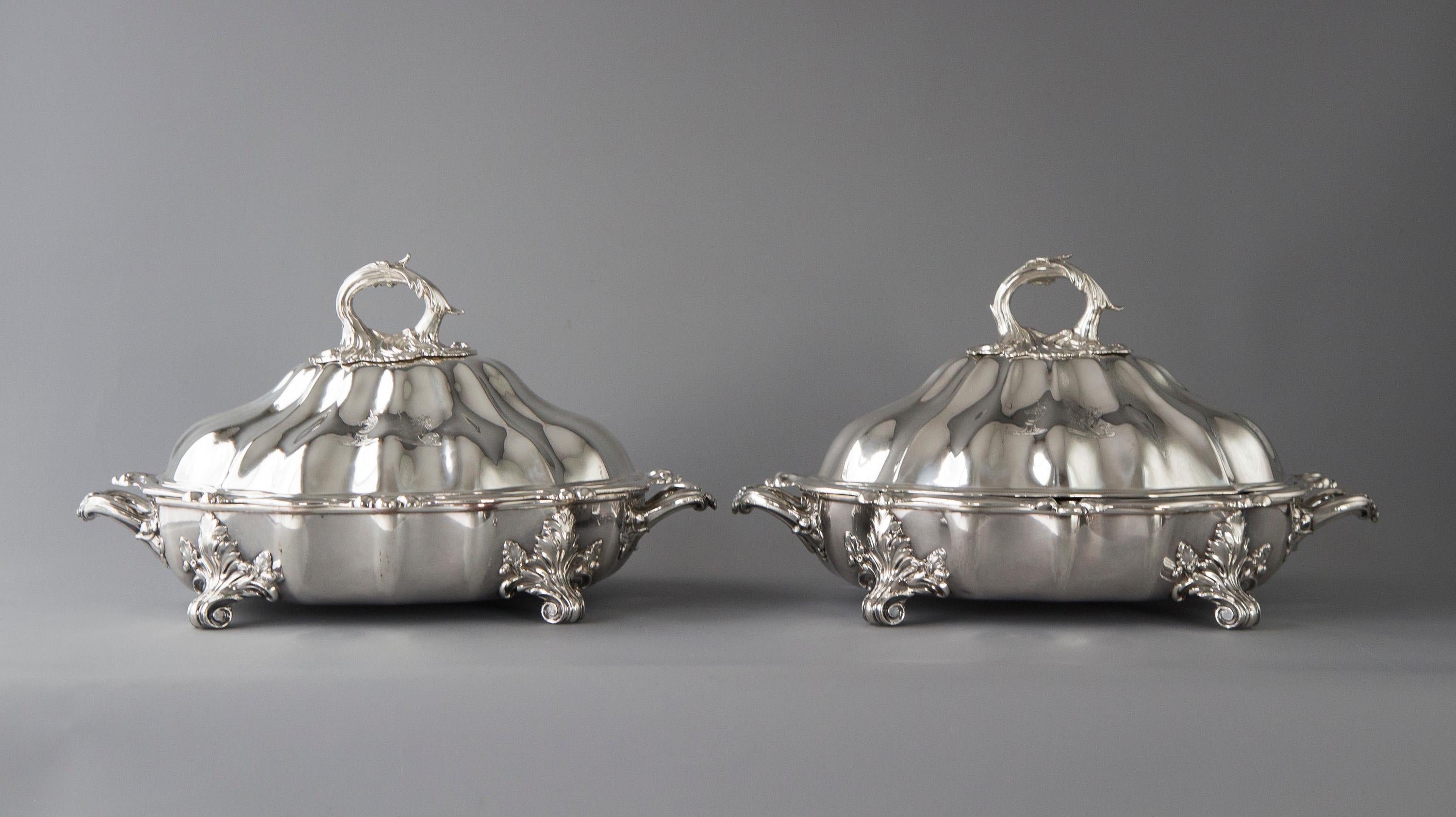 This superb pair of vegetable tureens or large entree dishes are of shaped, raised and fluted lobed form, surmounted with removable acanthus handles.
The lid is engraved to both sides with two crests (see pictures). The original plated warming