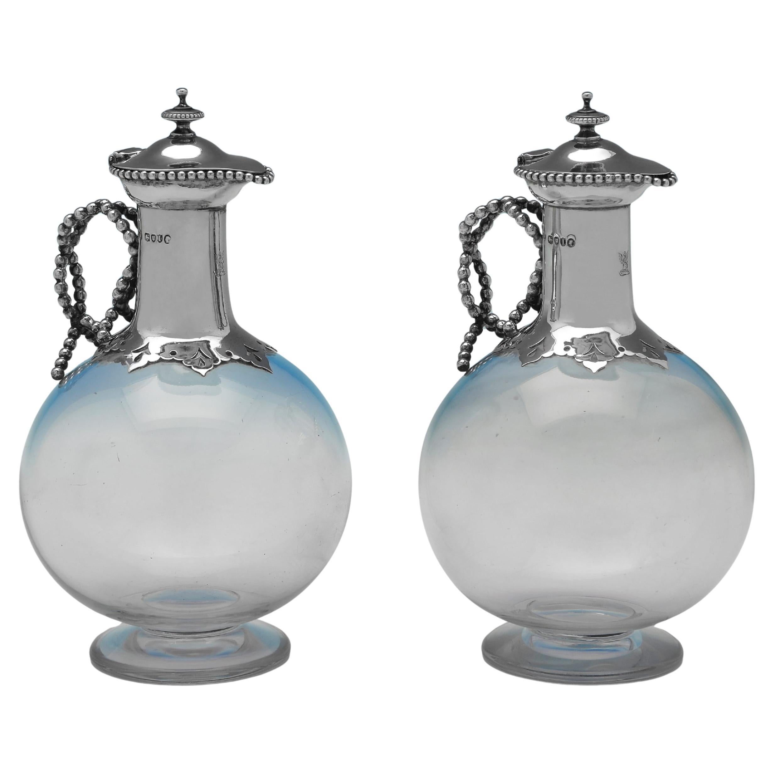 Pair of Victorian sterling silver and glass claret jugs made in 1884