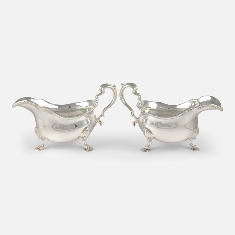A pair of early Victorian sterling silver sauce boats by D & C Houle, London, 1841. The sauce boats have shaped gadrooned rims, scroll handles, and fluted scroll legs terminating on shell feet.

Assay: - .925 (Sterling Silver).

Date: -