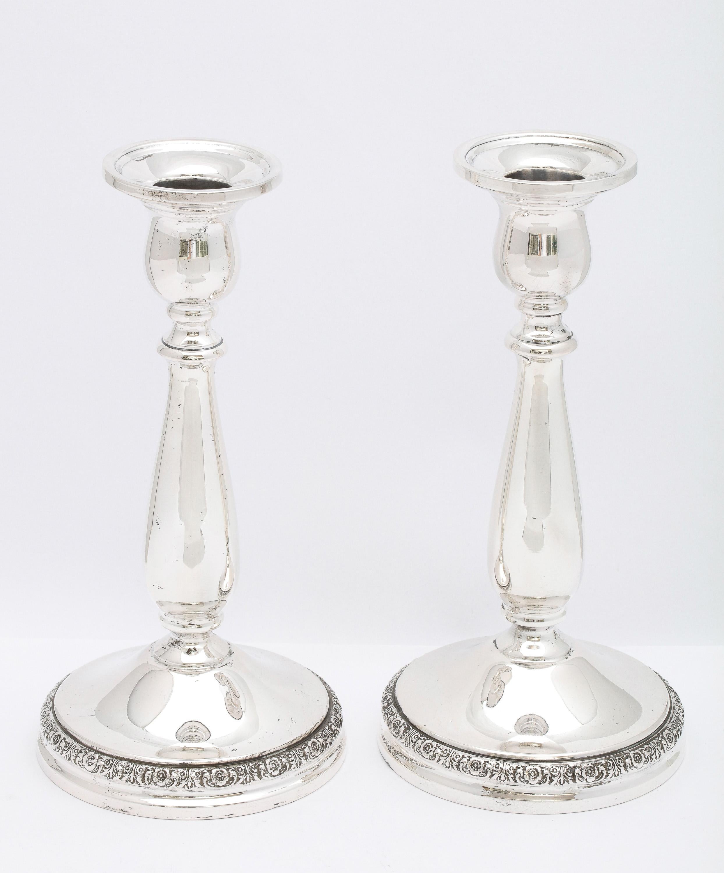 Pair of Victorian-Style sterling silver candlesticks, Simpson, Hall Miller Co. (division of International Silver Co), Meriden Connecticut, Ca. 1940's. Graceful design. The base edged in a tight, floral pattern. Measures 7 1/4 inches high x 3 3/4