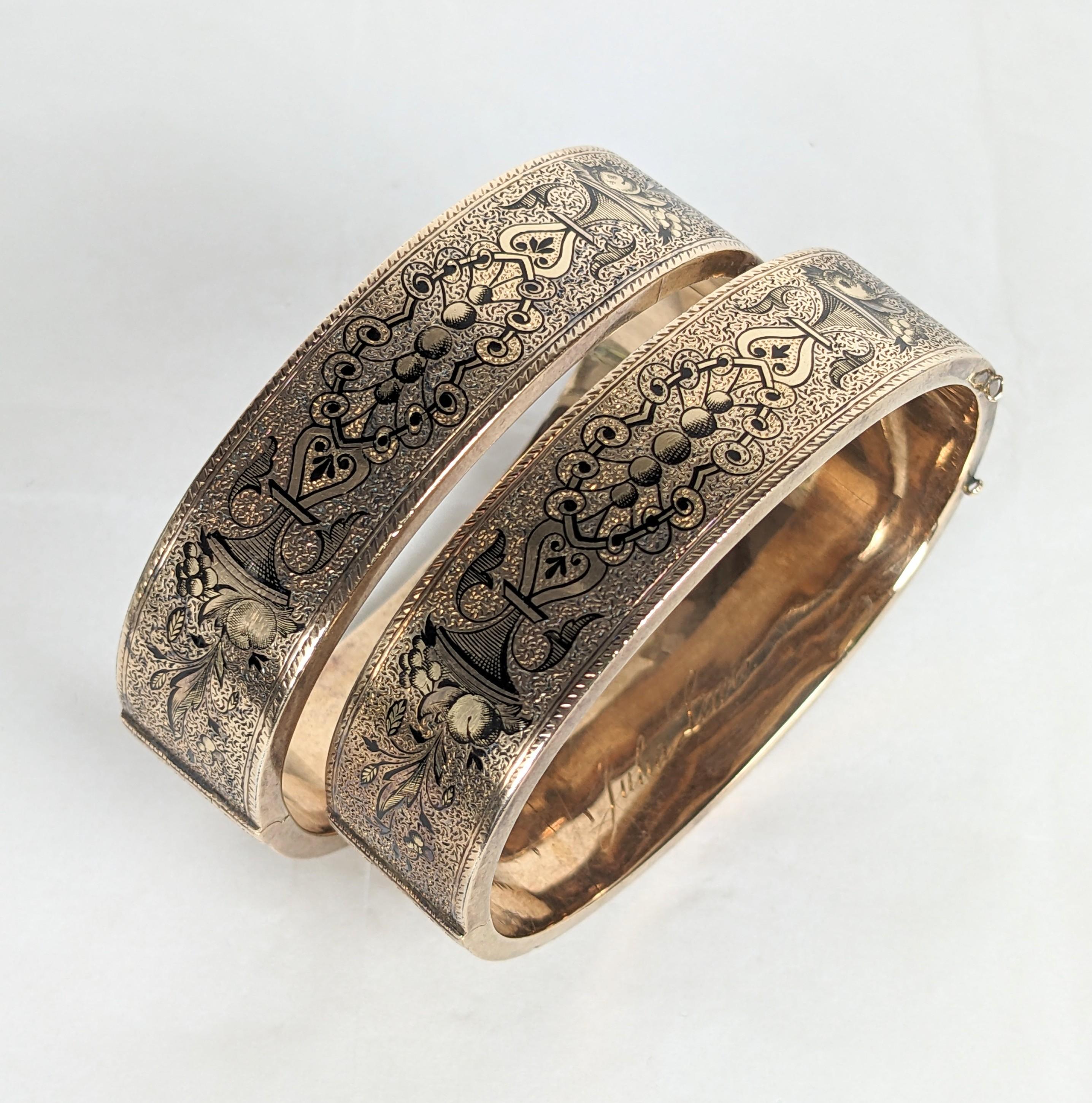 Coppia di bracciali vittoriani Taille d'Epargne smaltati a 14 carati degli anni '70 del XIX secolo. Una bella coppia abbinata con disegni ornati in smalto nero di eleganti cesti di frutta e trafori vittoriani su entrambi i lati. Dimensioni ridotte