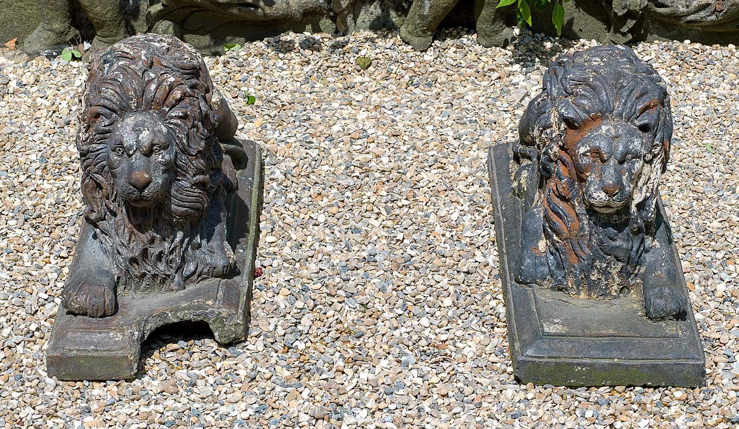 A pair of Victorian recumbent antique terracotta garden lions raised on molded bases - one base is damaged and they have once been painted and stripped - as found.
English, 19th century.