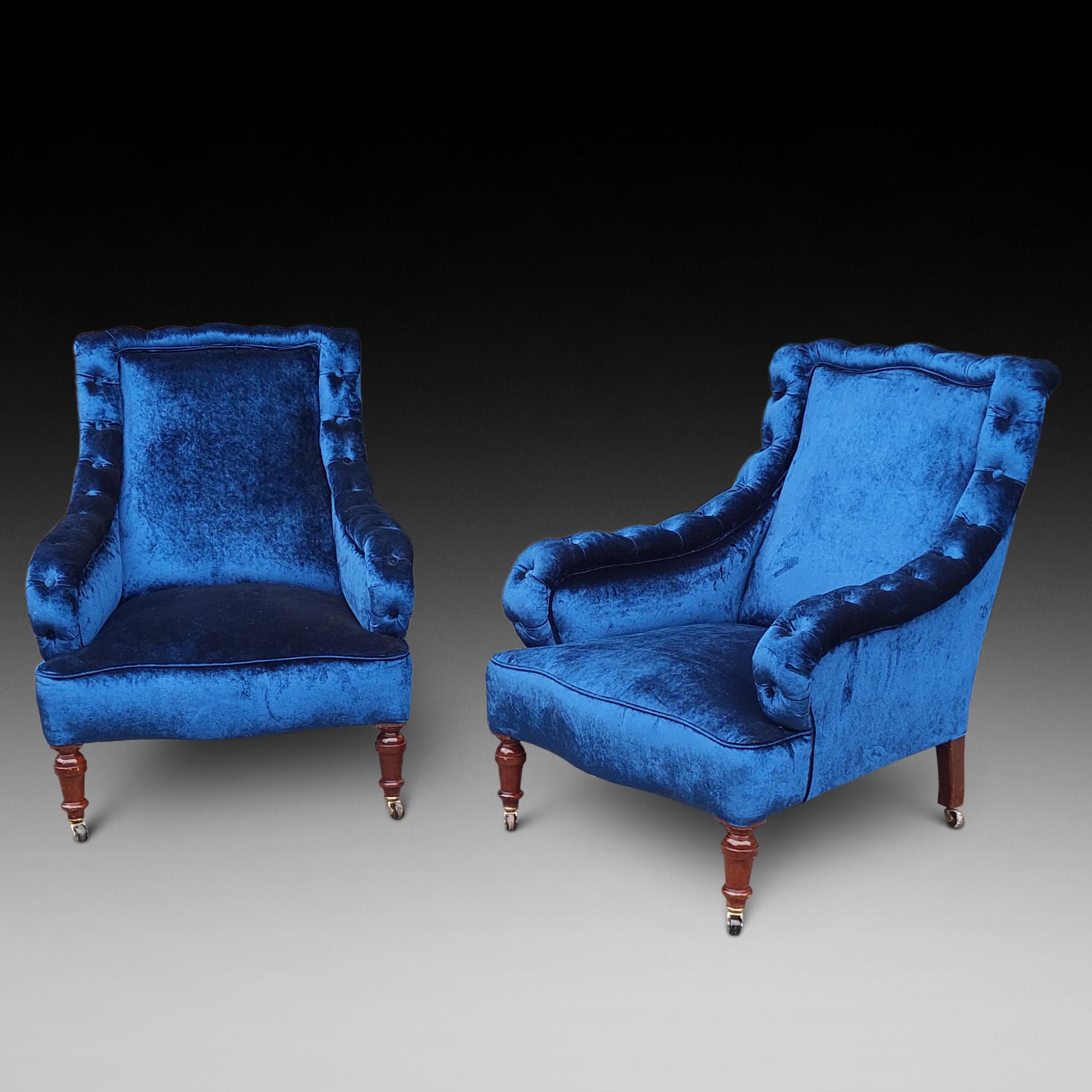 Paire de fauteuils victoriens en acajou, tapissés de velours bleu foncé, avec accoudoirs boutonnés, pieds avant tournés et pieds arrière en sabre avec roulettes 29 