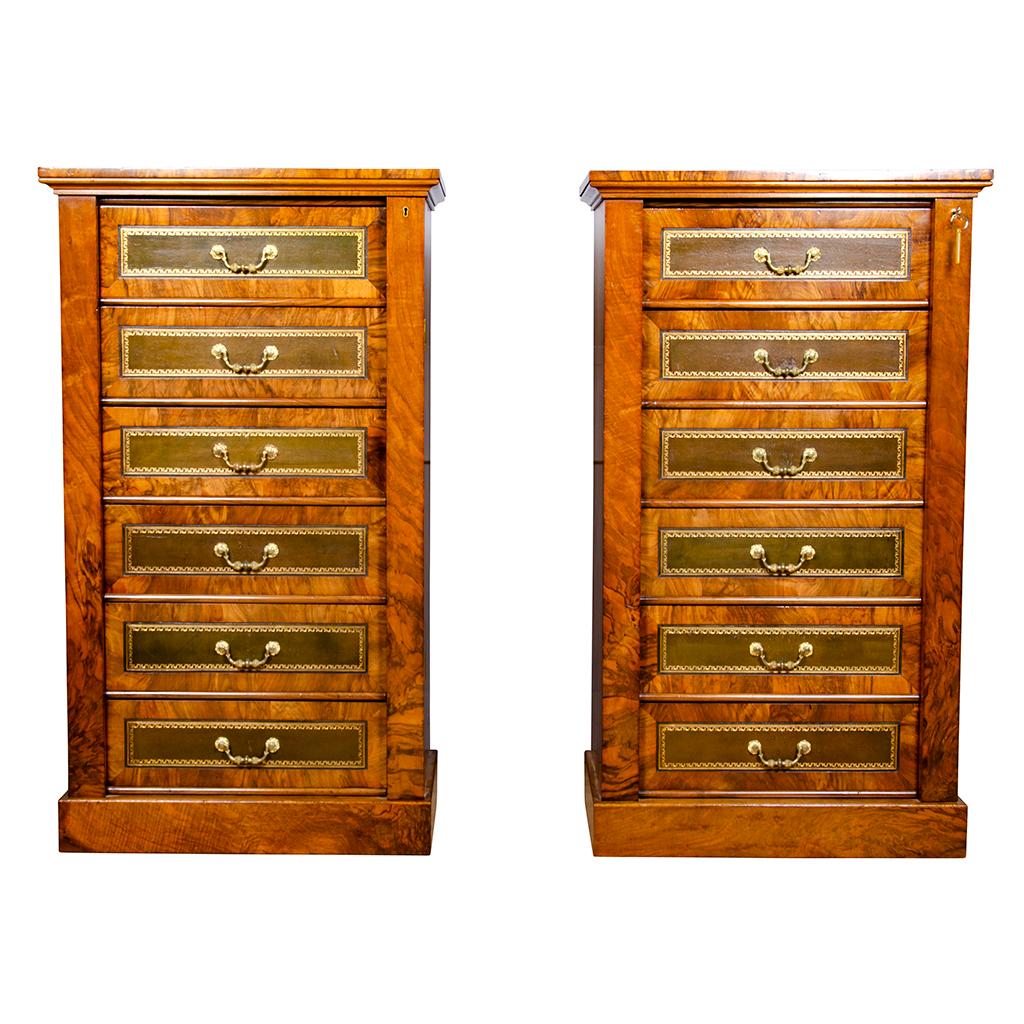 Each with squarish rectangular tops over six green tooled leather faced drawers with cast bail handles the whole with hinged lock side mechanism with key. Plinth base.