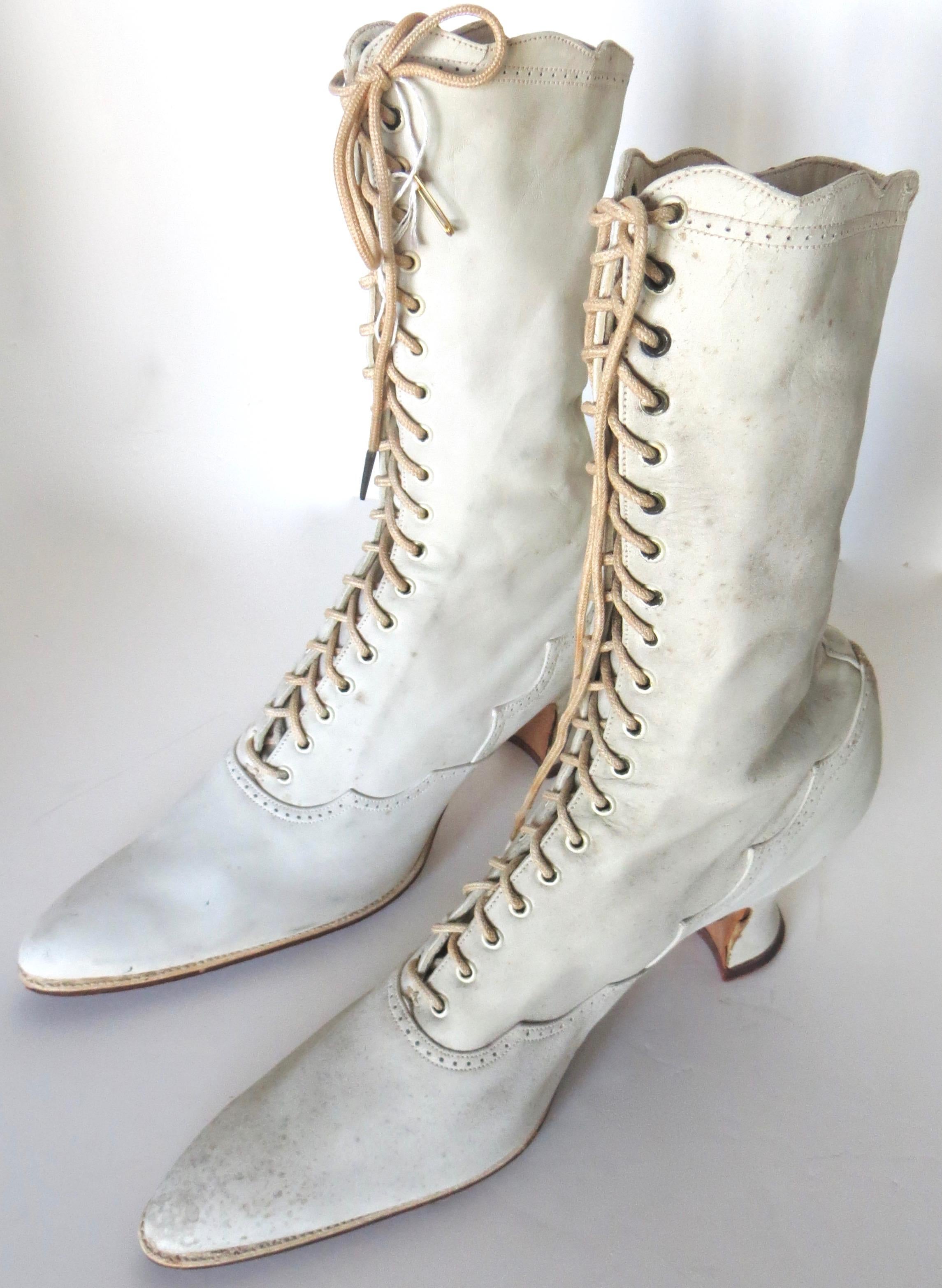 Dress up your wardrobe with these authentic, vintage, high top white kid leather boots with a generous amount of shoelace loops; wearable and in very nice condition--small size; lady's size 5 (narrow). 
The kid leather on these American Victorian