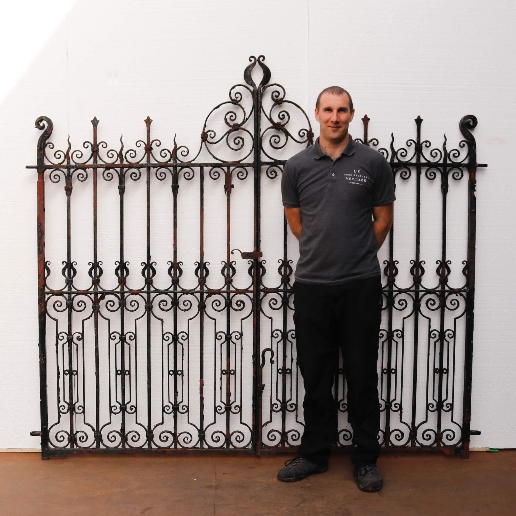 Pair of original Victorian elaborately crafted wrought iron driveway gates crafted in circa 1880. These 19th century gates do not disappoint in size and design. Rows of elongated scrolls and swirls are matched structurally with the original working
