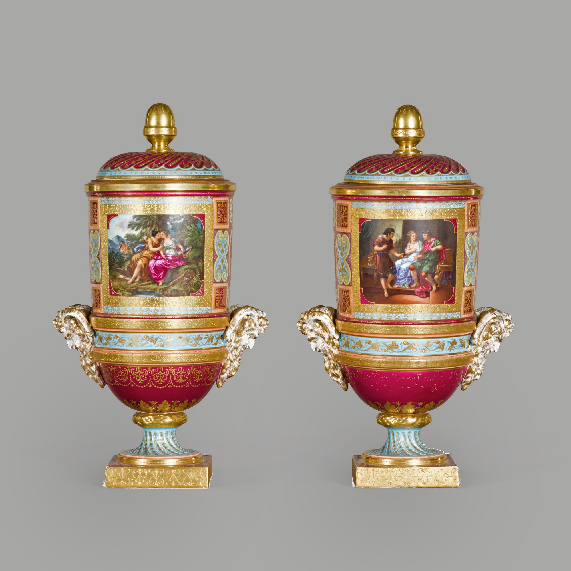A fine pair of Vienna style covered cylindrical vases, on square footed socle bases.

The vases are decorated with classical scenes including Jupiter and Callisto, after Angelica Kauffman and Bacchus and Ariadne. The vases have satyr head handles