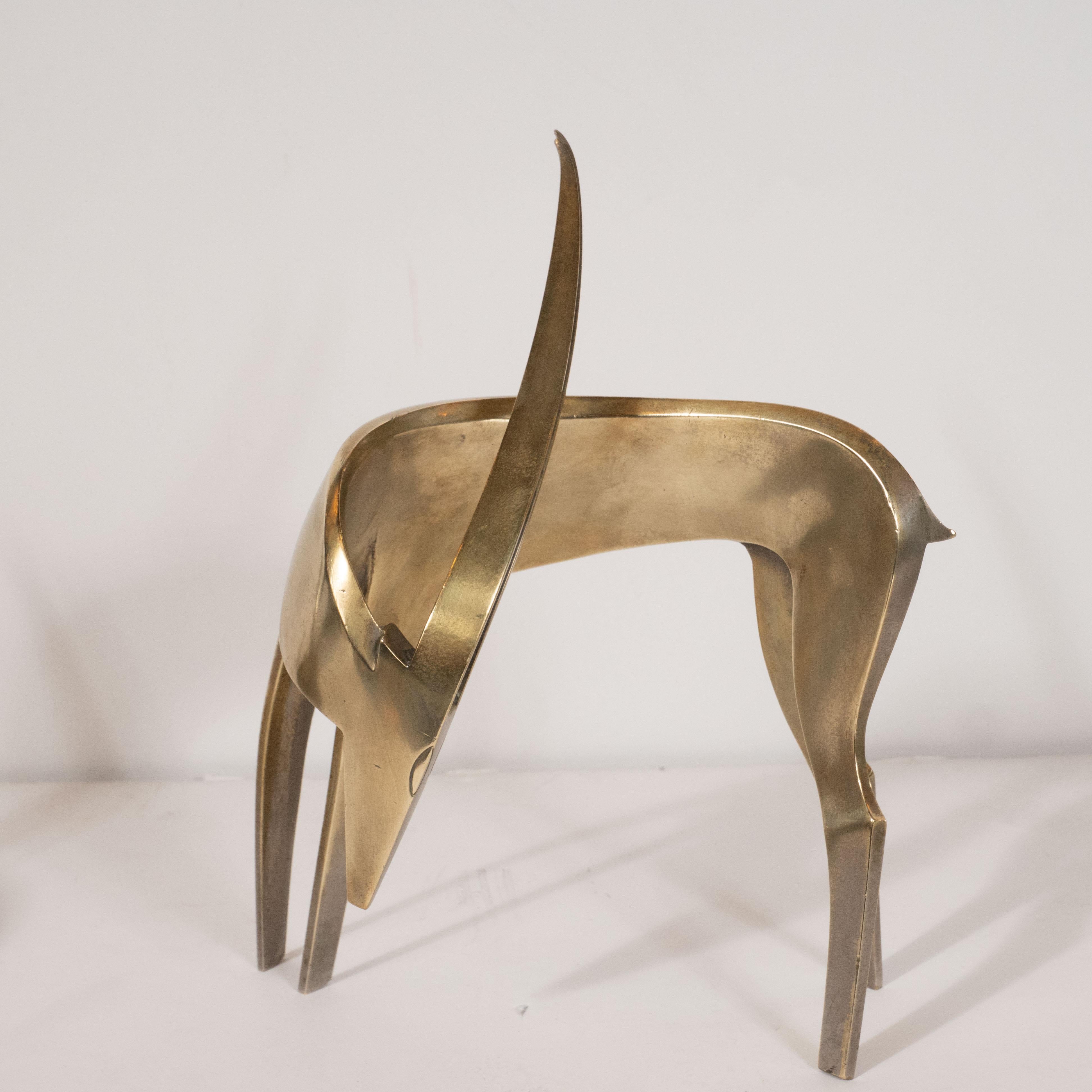 This refined pair of Art Deco stylized waterbuck brass sculptures were realized in Vienna, circa 1940. They feature abstracted interpretations of the waterbuck- an African plains antelope- one lying down, the other upright and both with their heads