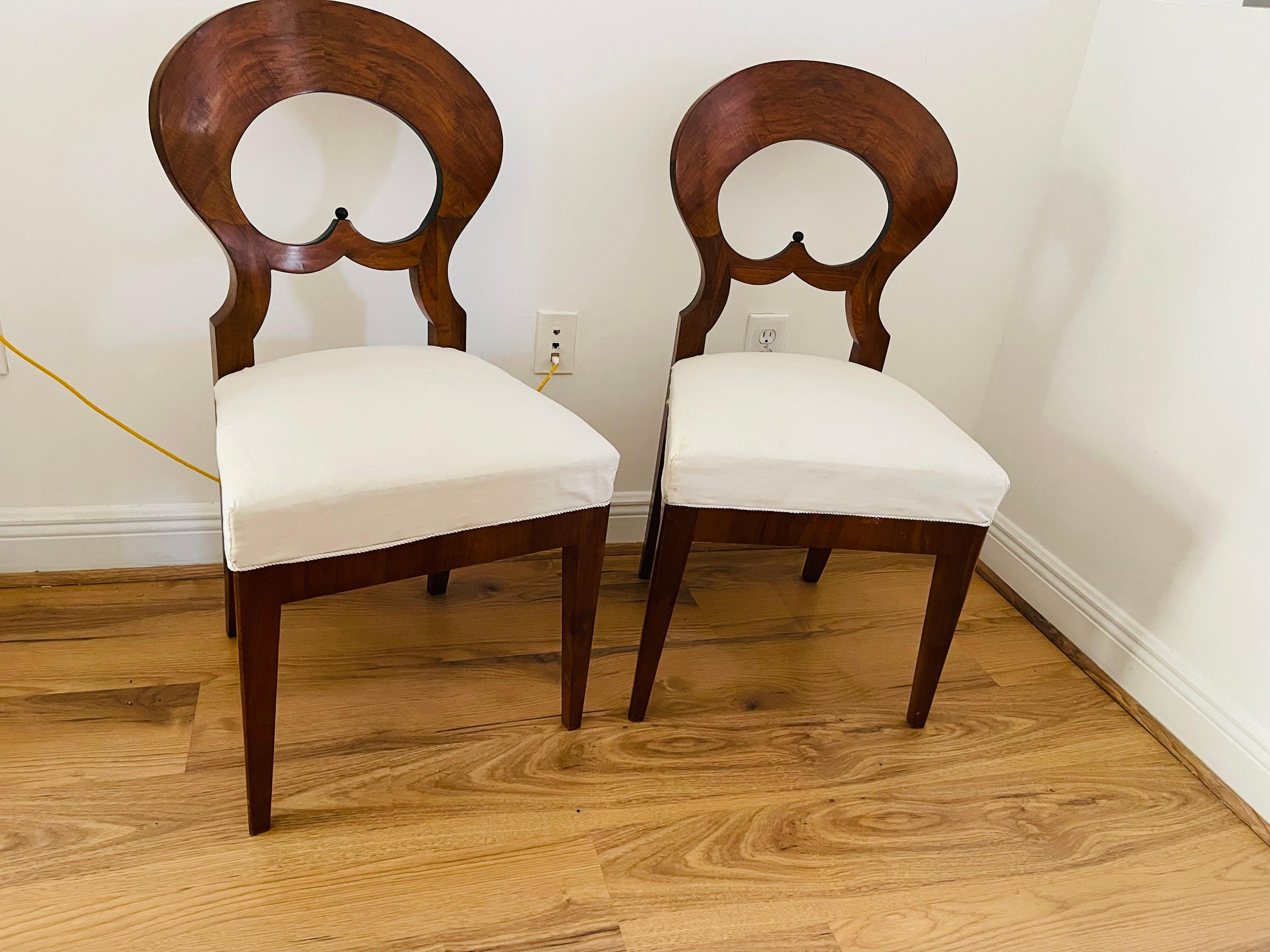 Pair of Viennese 1820 walnut veneer chairs with round backs and ebonised decor. Original horse hair see weed upholstery. Polished with shellack. Reupholstered in French linen. Great condition/ solid and comfortable seating.