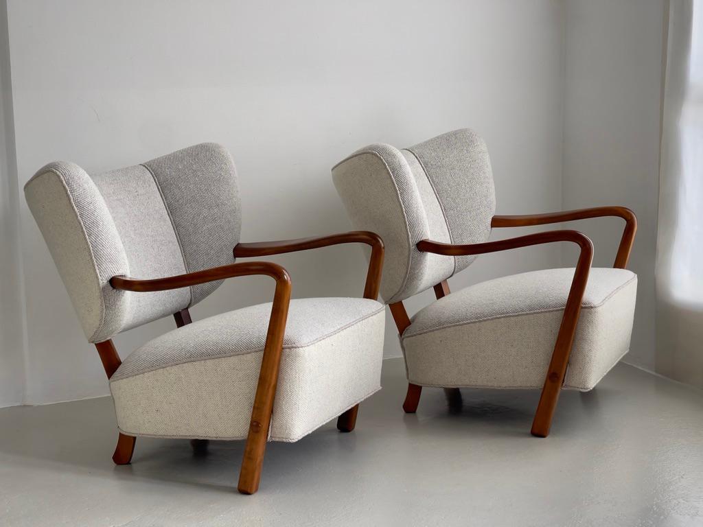 Esta rara y excepcional pareja de sillones de salón modernos daneses, atribuidos a Viggo Boesen y fabricados por los distinguidos ebanistas de Hos Wulff en Copenhague durante la década de 1930, encarna la suavidad escultural y la elegancia orgánica