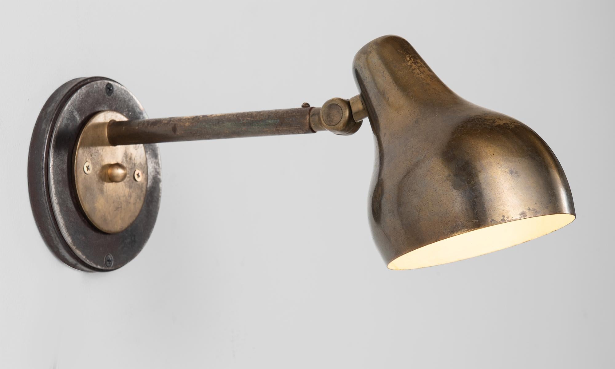 Pair of Vilhelm Laurtizen wall lights by Louis Poulsen, Denmark, circa 1942.

Adjustable brass sconce with oxidized steel backplate.
