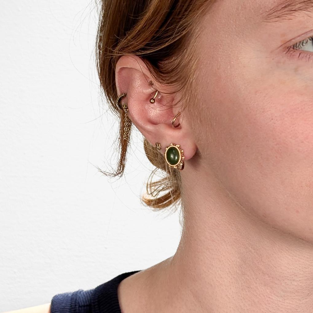 A fine pair of vintage gold & jade screwback earrings.

In 14 karat yellow gold.

Each with a central jade (nephrite) cabochon surrounded by gold openwork petals.

Marked for fineness to each screwback.

Simply a wonderful pair of jade
