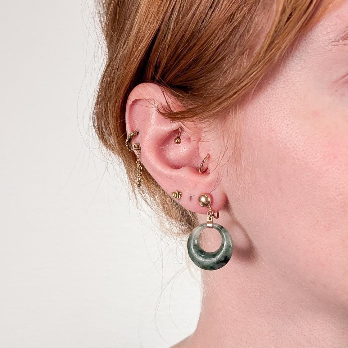 A fine pair of vintage Chinese jade & gold hoop earrings.

In 14k yellow gold.

Each with a tapered spinach jade (nephrite) hoop suspended from 14k yellow gold mount with a screw back closure.

Marked 14k to the back of the ear back.

Simply a