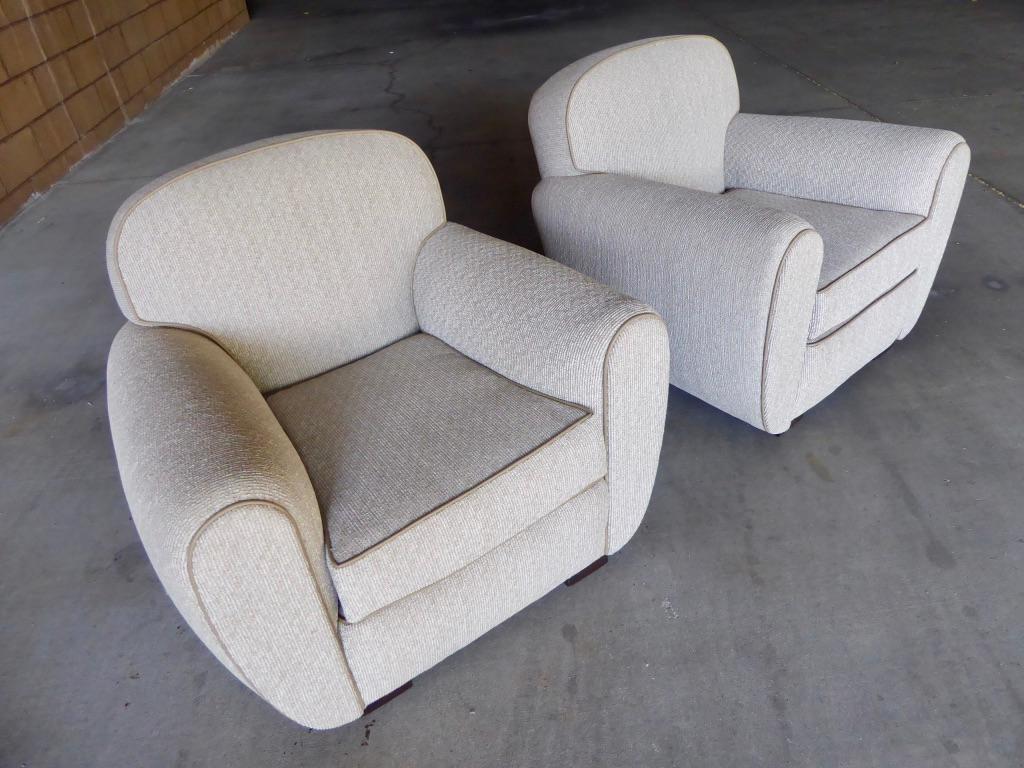 A vintage pair of French Art Moderne club chairs, circa 1930s. Newly reupholstered in a luxurious corduroy style textured fabric with a contrasting piping that provides definition to the entire chair.