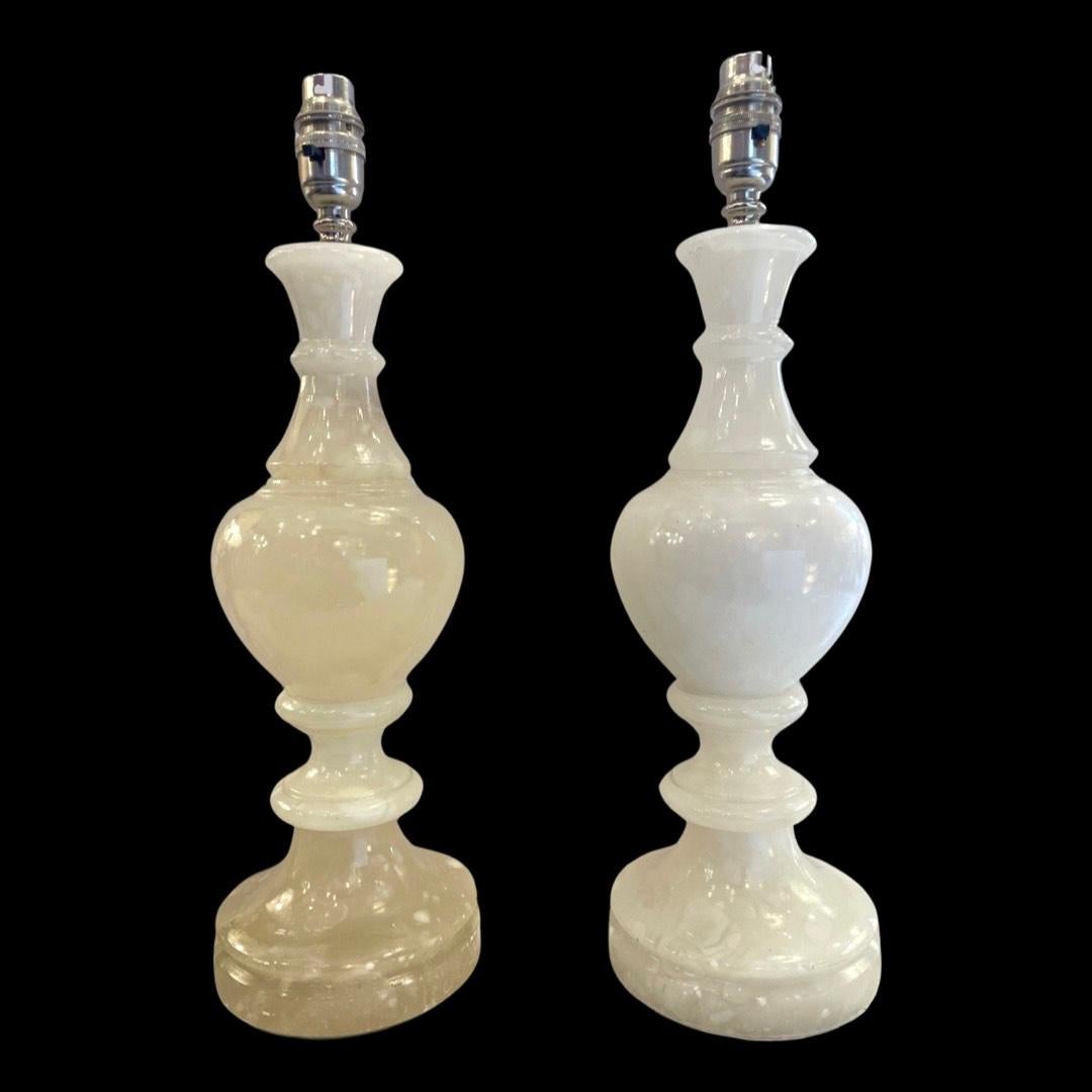 An exquisite pair of 1980's white alabaster urn-style table lamps.

These vintage treasures boast a stunning, highly polished finish that imparts a captivating glow to the alabaster, creating an ambiance of timeless elegance.

Revel in the