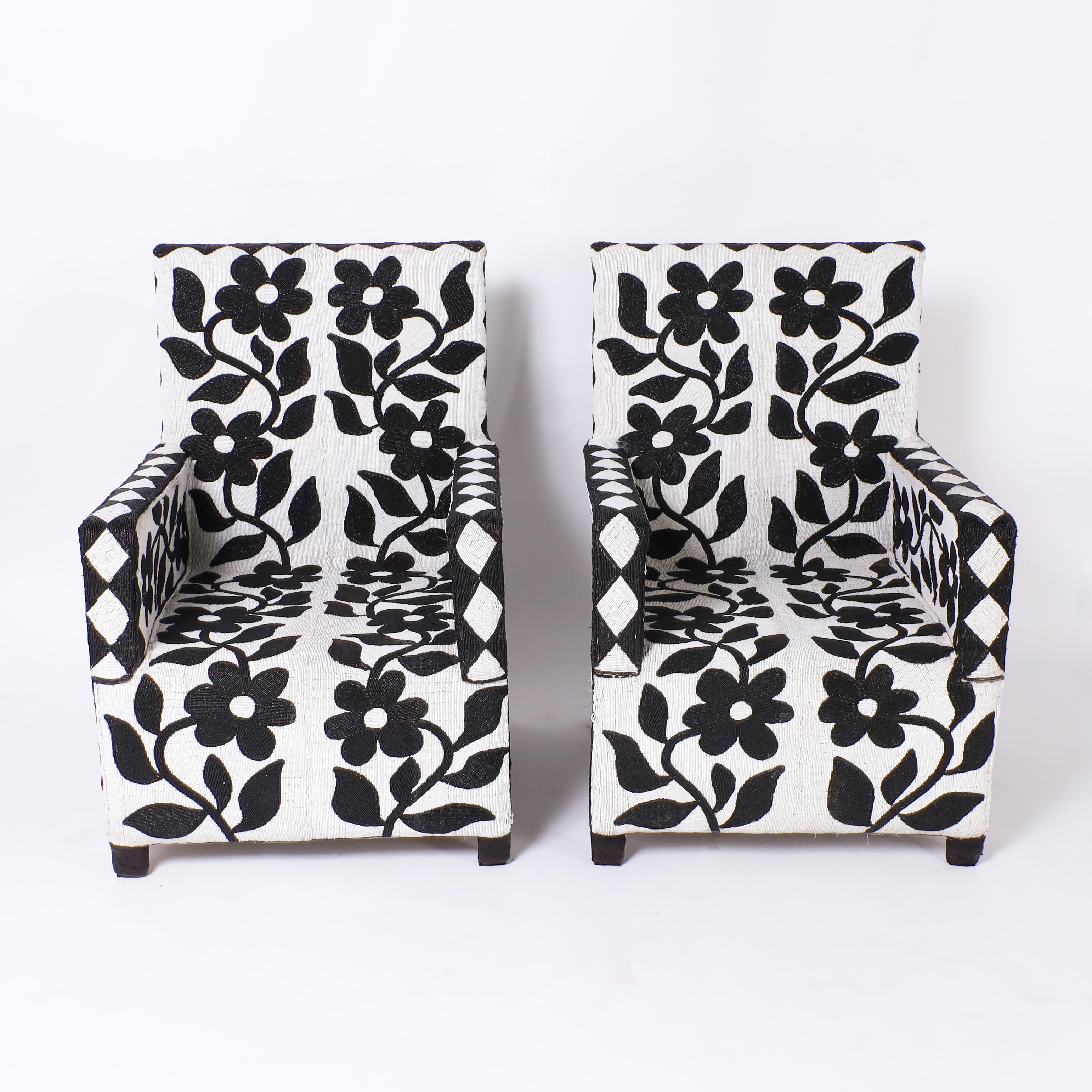 Impressive pair of Nigerian armchairs, ambitiously handcrafted by the Yoruba tribe with glass beads on fabric on a wood frame in a striking black and white floral design. 