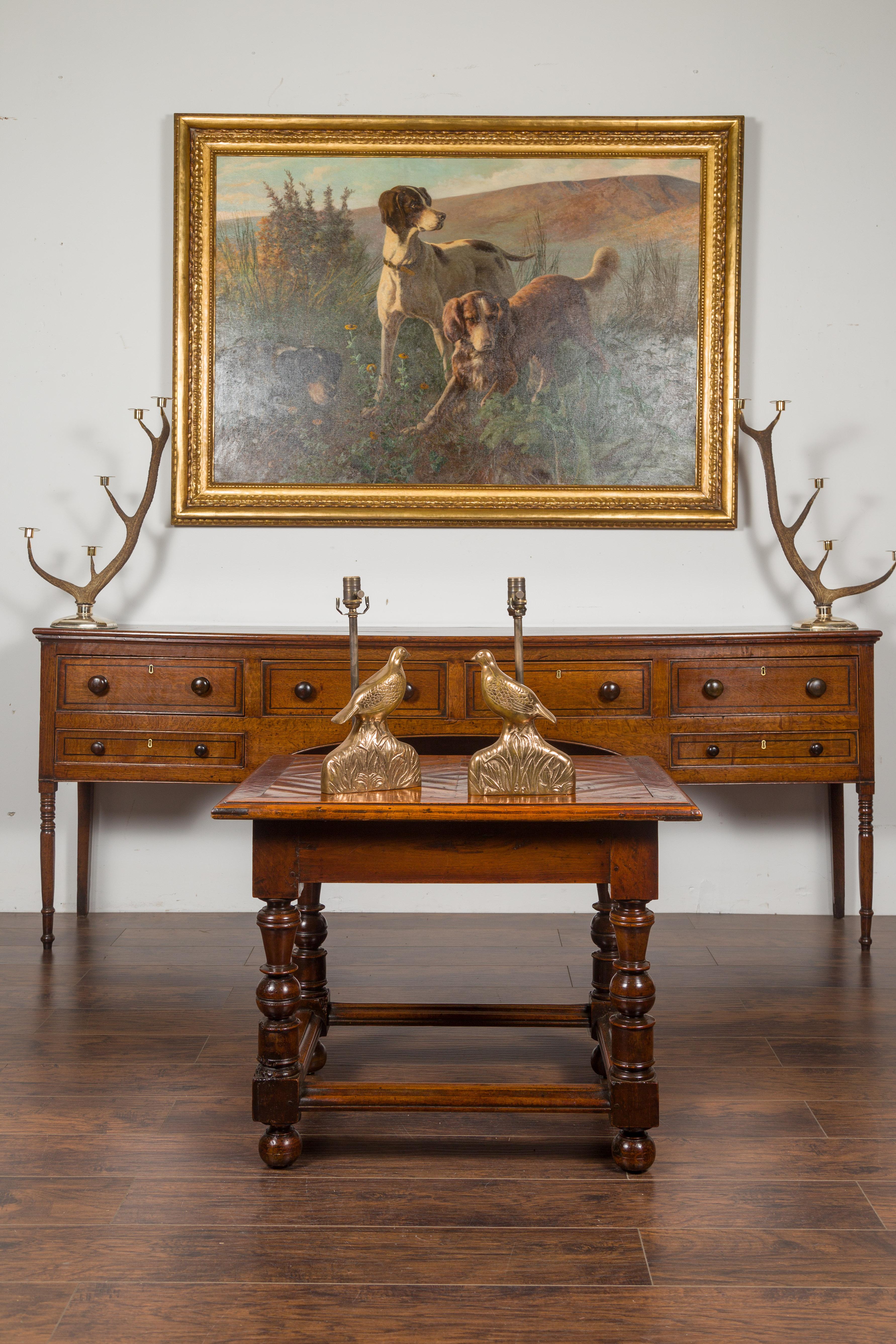 A pair of vintage American bronze quail table lamps from the mid-20th century, on foliage base. Wired for the US, each of this pair of bronze table lamps draws or attention with its lovely depiction of a quail peacefully standing on grass. With