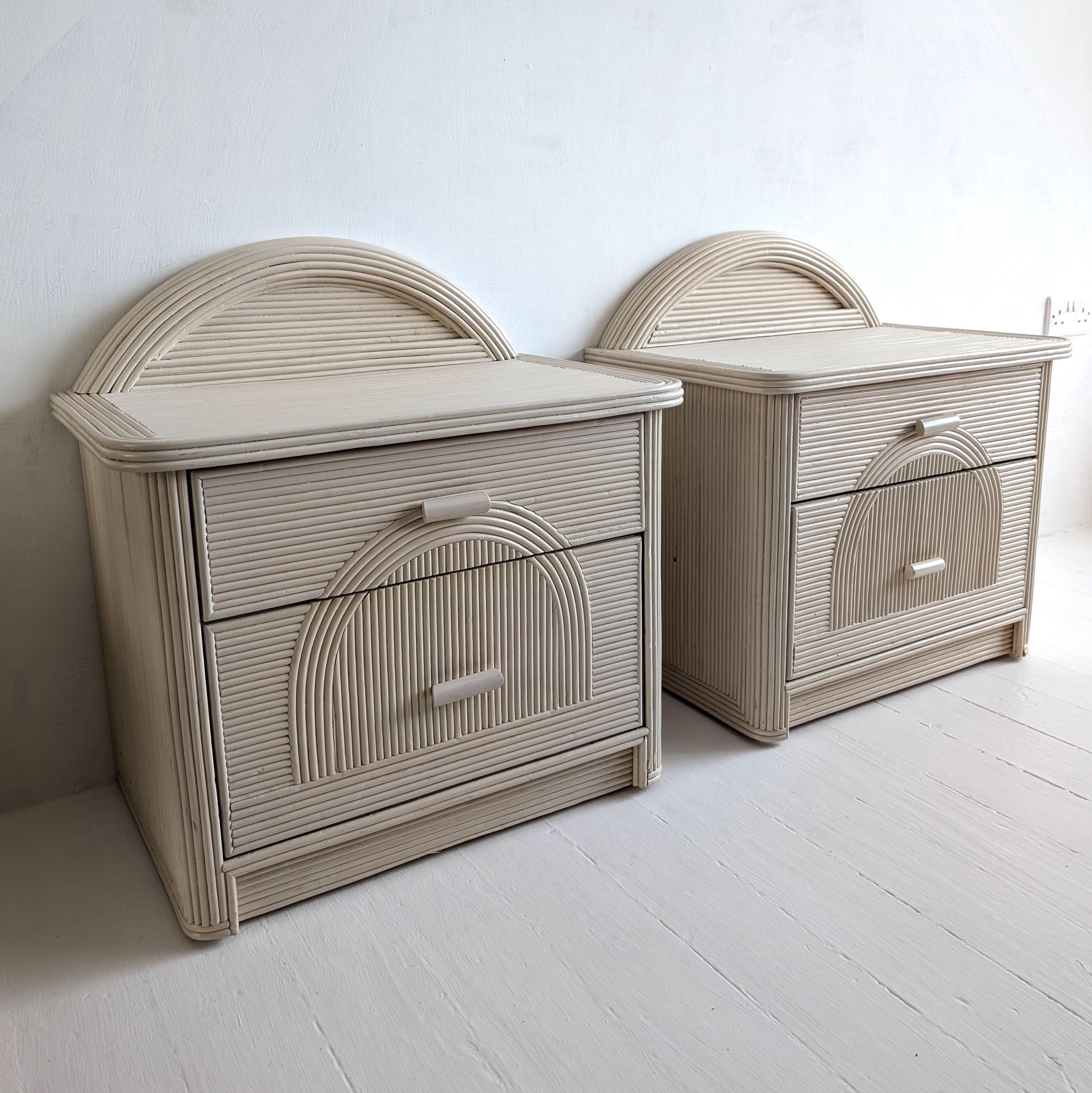 Pair of vintage American pencil reed bedside cabinets with arched backs. Each has two drawers. 1980, USA. Original off white / ivory paintwork finish.

Dimensions: width 63.5cm, total height 67.5cm, depth 40cm
