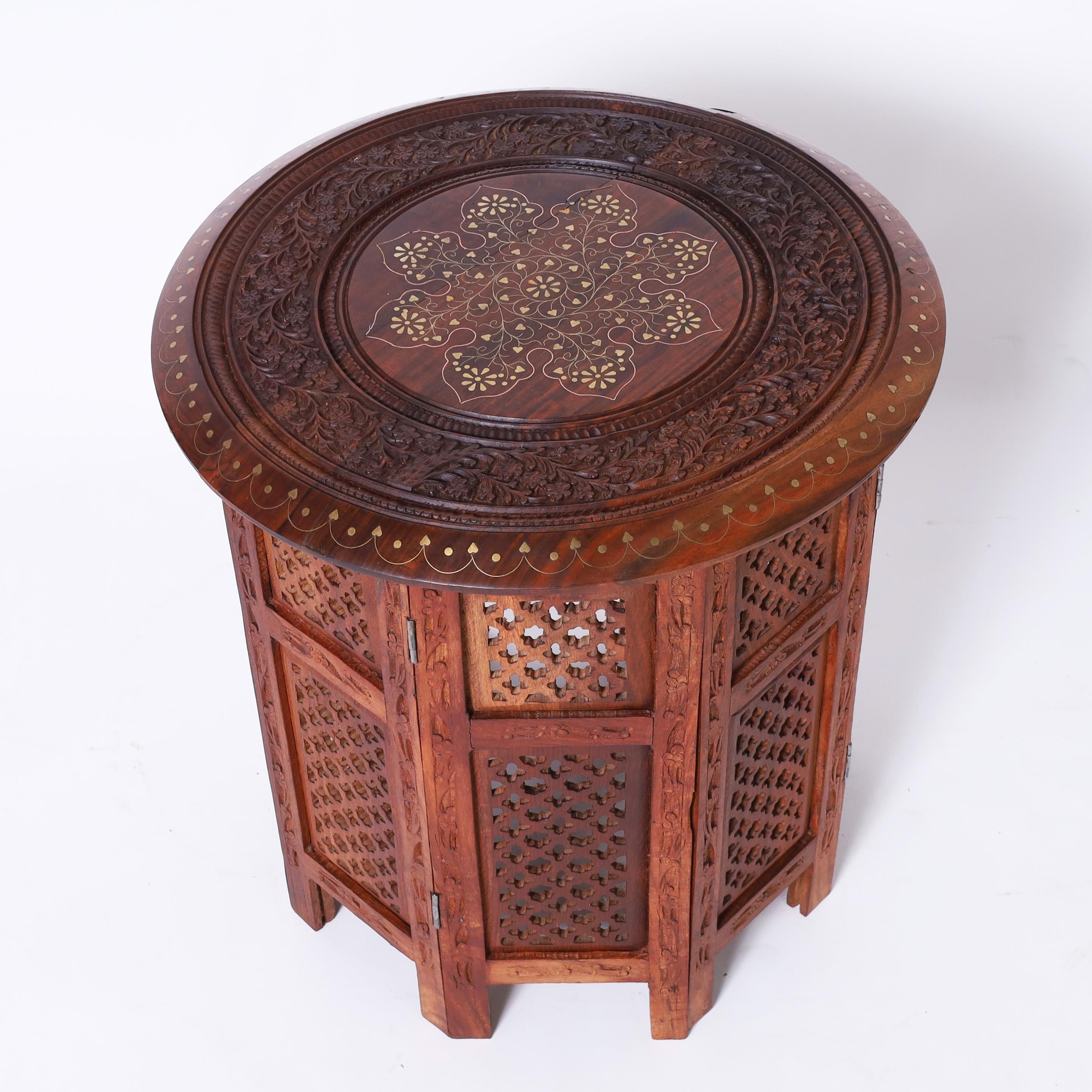 Standout pair of vintage Anglo Indian stands crafted in teak wood having round tops with brass inlays and floral carvings over an octagon form base with open fretwork.