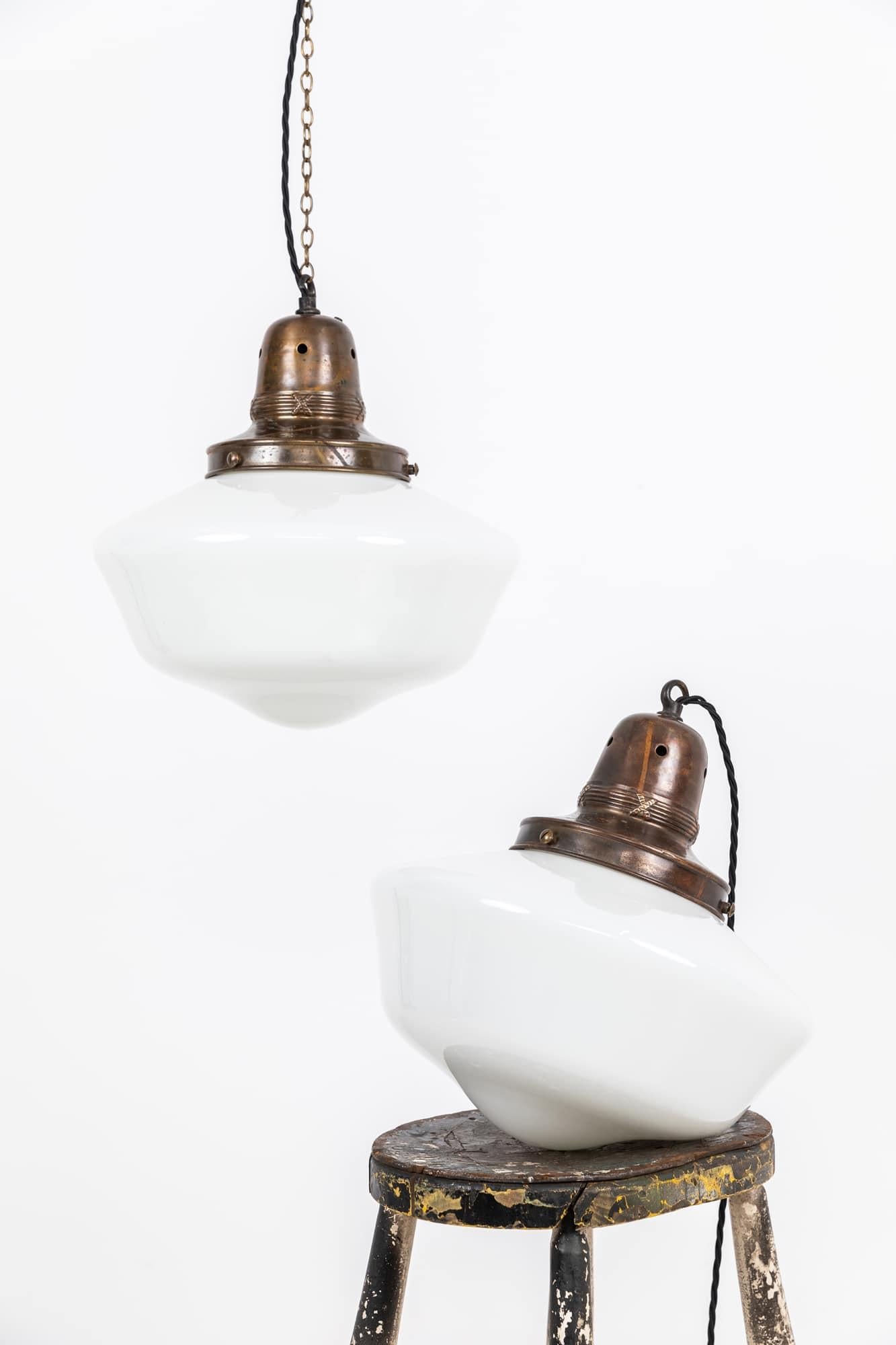 Pair of beautifully formed large opaline glass pendant lights. c.1930

Heavy gauge moulded opaline glass shades, this shape of lamp were commonplace in churches and chapels up and down the country in the early 20th century. Complete with brass