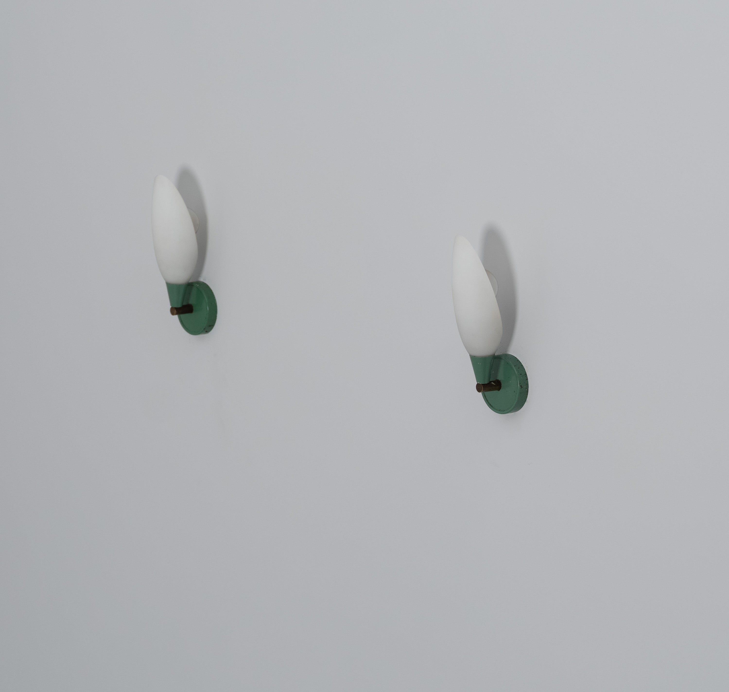 Pair of vintage appliqués manufactured in Italy during the 1950s.

This pair of wall lamps are made of green enameled metal, two opaline glasses and brass. 

This light have a modern and minimal typical Italian design of the 1950s.

Original