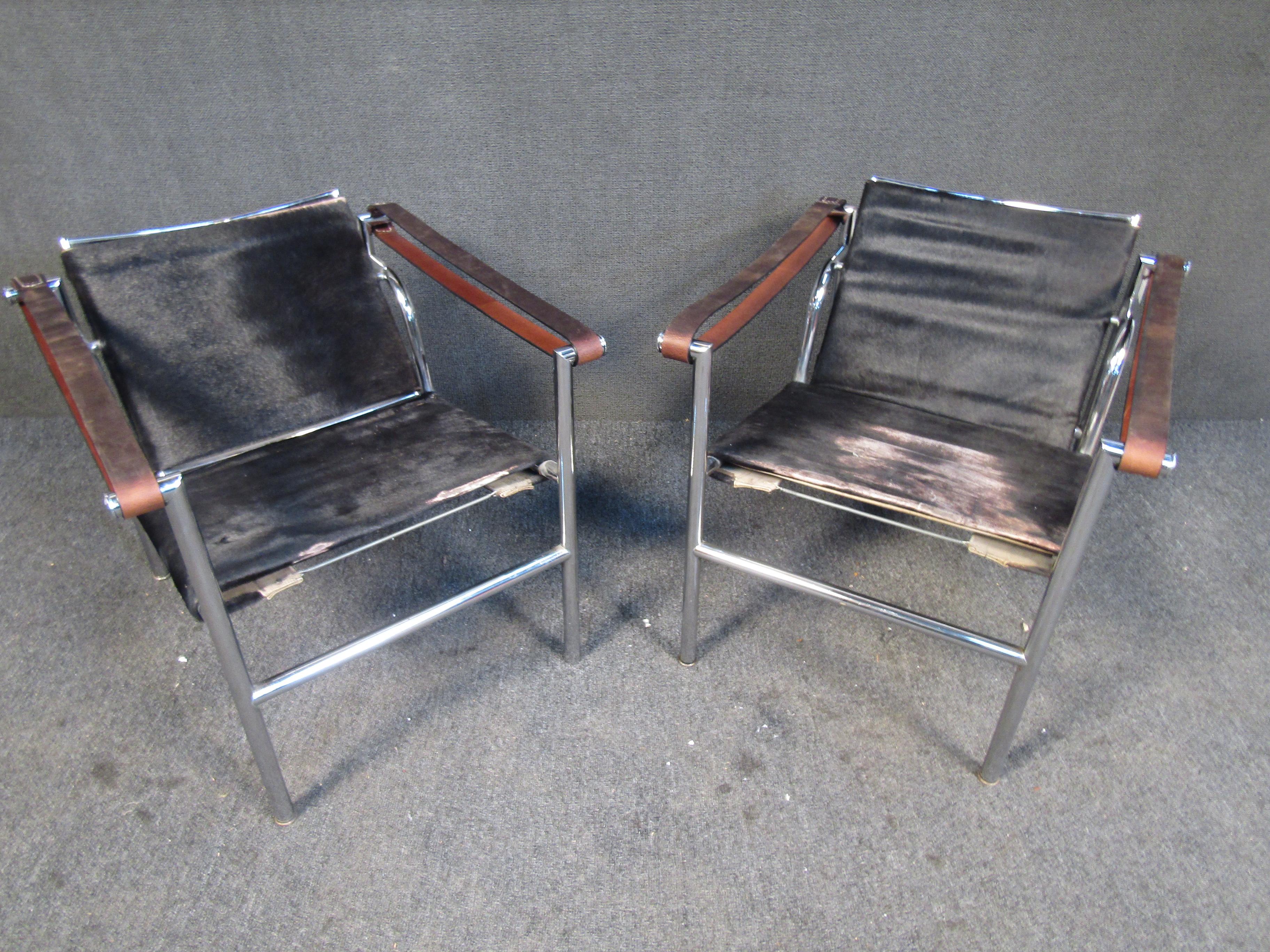This vintage pair of stylish armchairs by Cassina combine chrome frames with leather strap arms and unique seats. Please confirm item location with seller (NY/NJ).