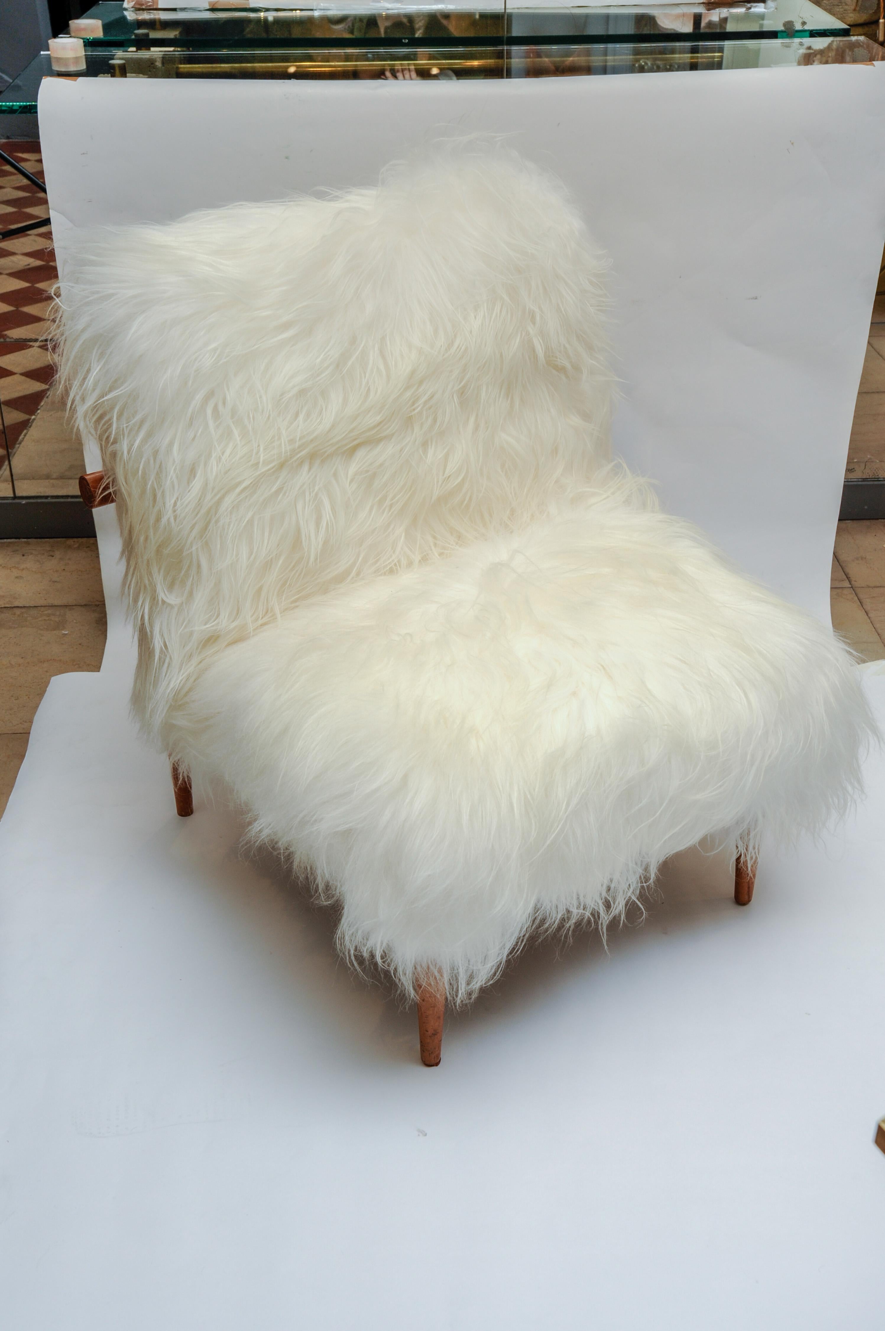 Reupholstered with natural Mongolian goat fur, this pair of armchairs has a Scandinavian 1960s wood structure.
