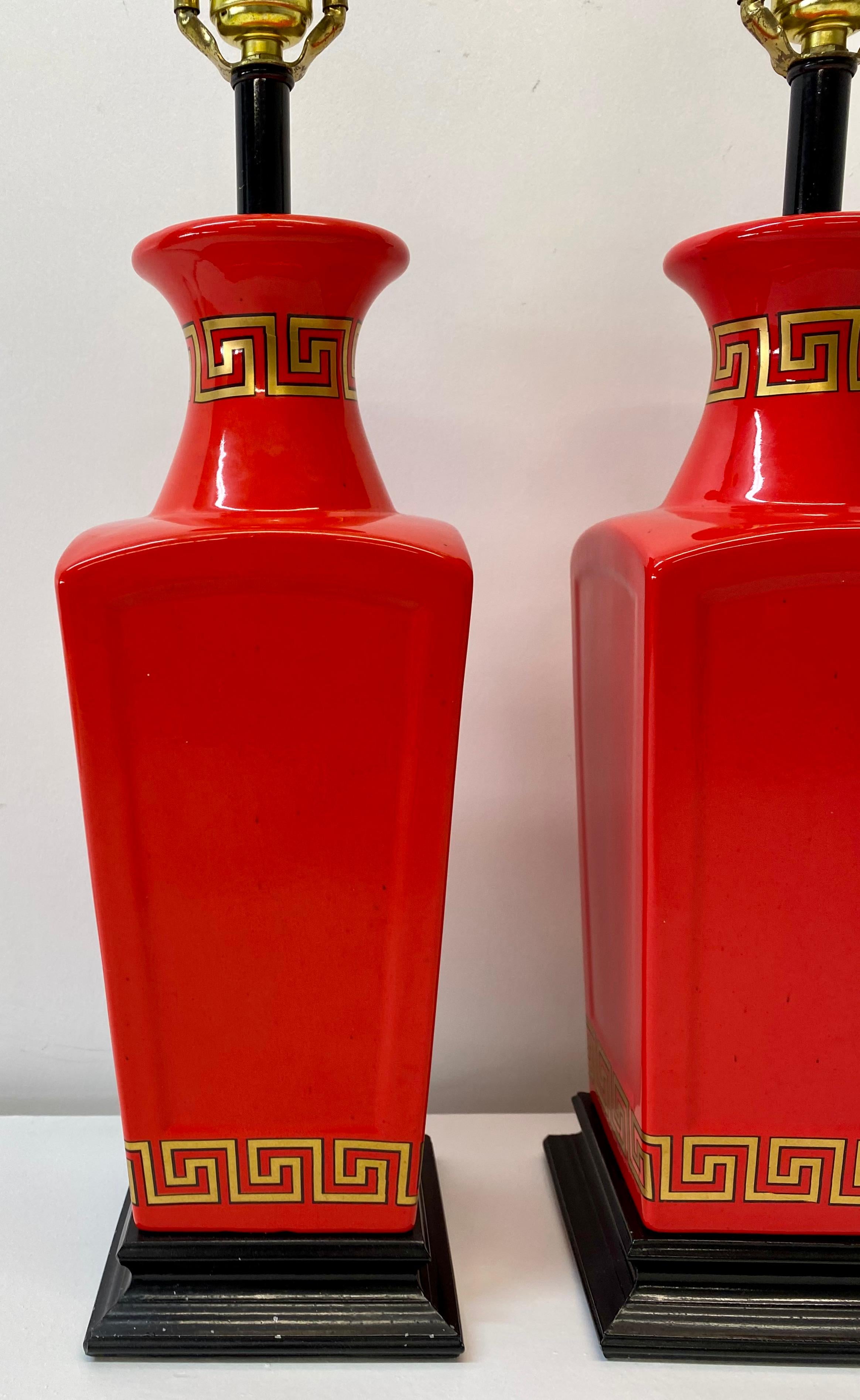 Pair of vintage Asian inspired Chinese red table lamps, circa 1960

Hand painted geometric pattern in gold with black border 

Absolutely gorgeous eye-popping red accented with black and gold

These are some of the most beautiful lamps in our