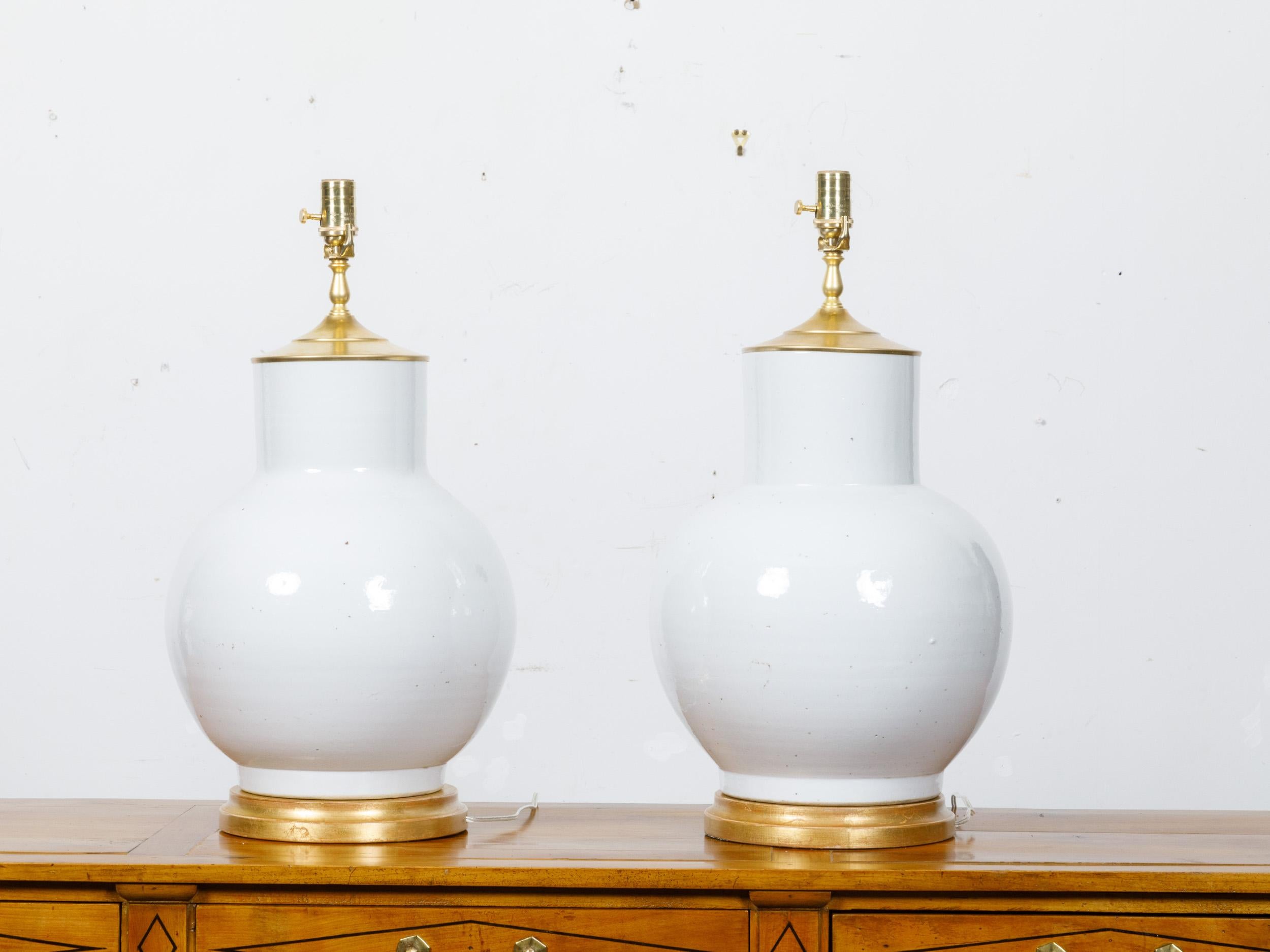 Paire de pots à gingembre en porcelaine asiatique montés comme lampes de table et câblés pour les Etats-Unis. Cette paire de lampes dégage une élégance intemporelle, avec leurs bases gracieusement arrondies typiques des formes traditionnelles des