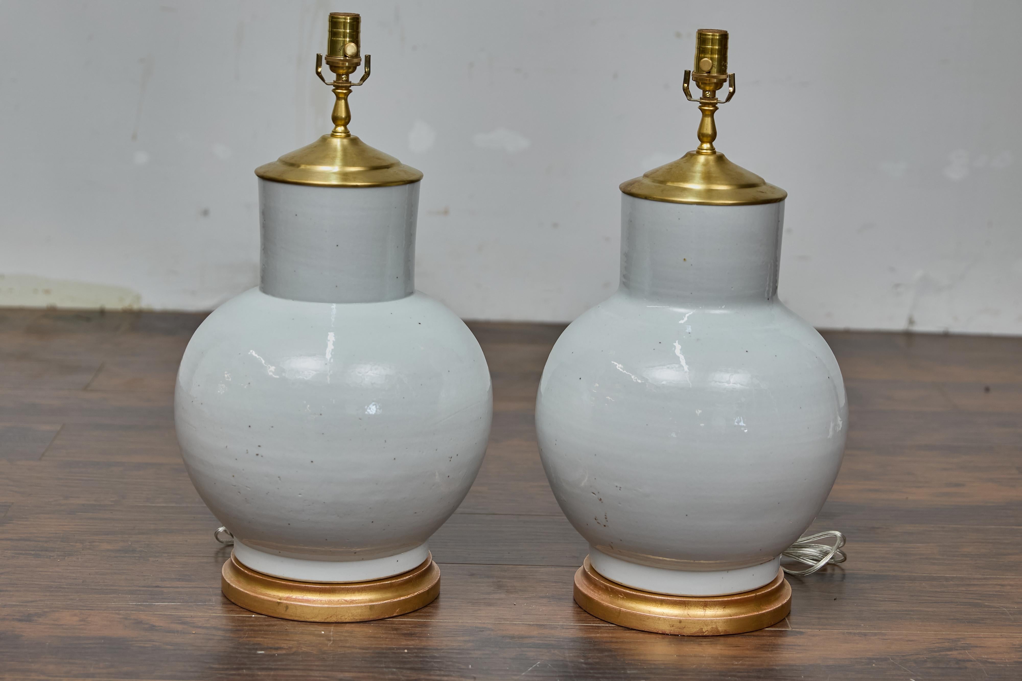 Paire de pots à gingembre en porcelaine asiatique montés comme lampes de table et câblés pour les Etats-Unis. Cette paire de lampes dégage une élégance intemporelle, avec leurs bases gracieusement arrondies typiques des formes traditionnelles des