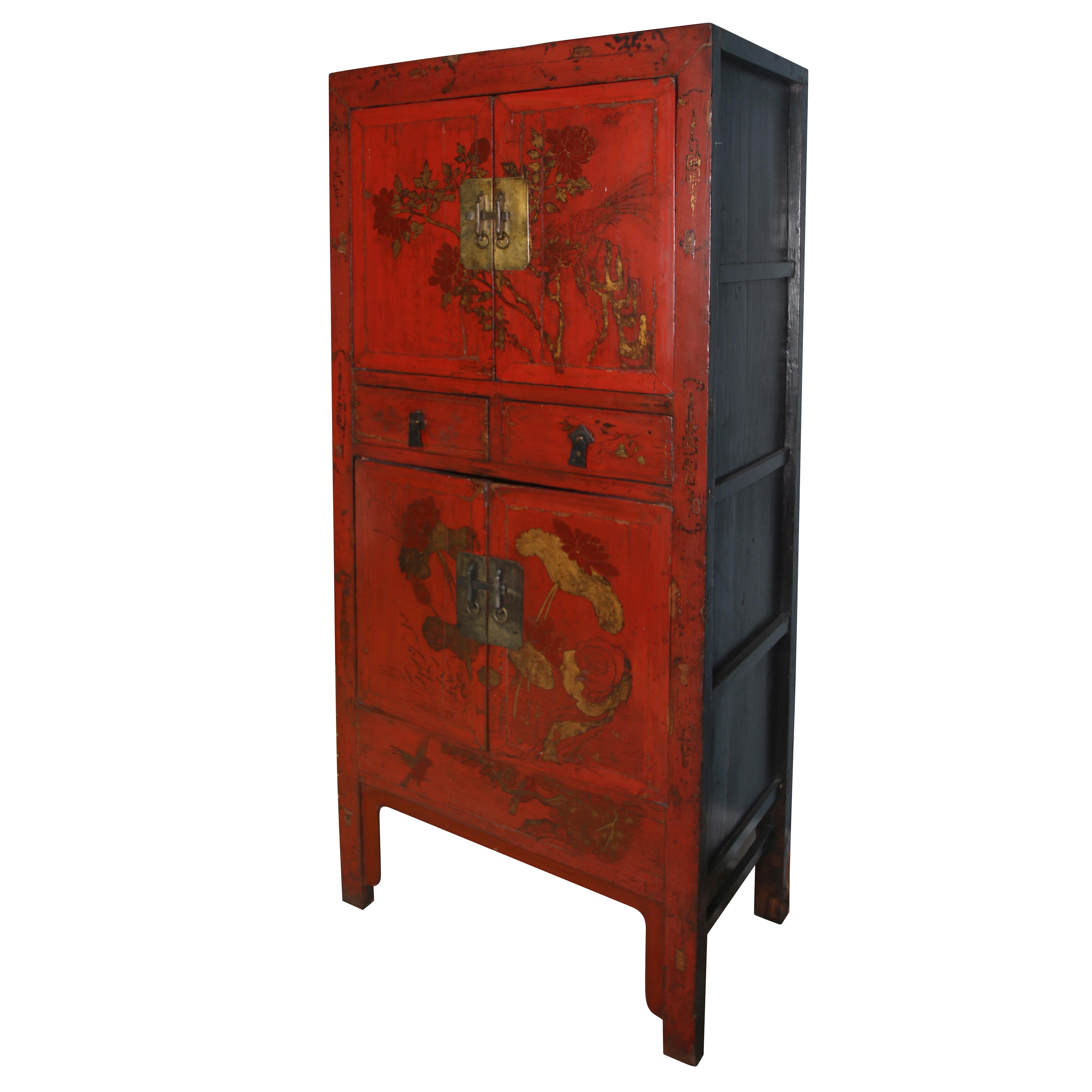 A pair of tall vintage Asian red lacquer cabinets with gold branch and leaf design and square brass hardware. Two small center drawers are flanked by pairs of doors above and below that open to reveal shelves.