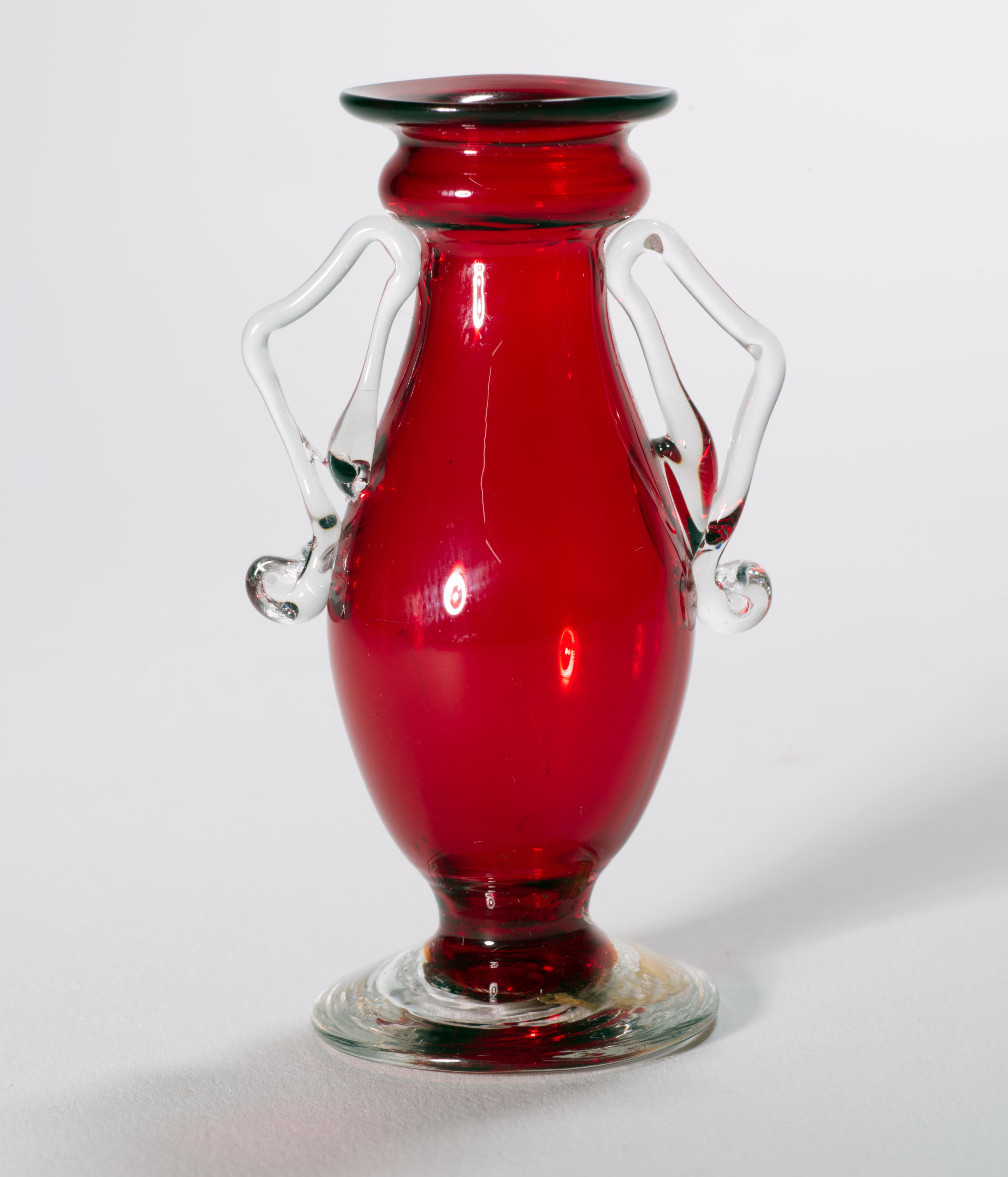  Una coppia di suggestivi mini vasi di gemme soffiati a mano è stata realizzata in vetro rosso rubino con basi e manici in vetro trasparente; il vaso più grande presenta inclusioni di foglie d'oro e bolle controllate nel vetro trasparente, mentre il