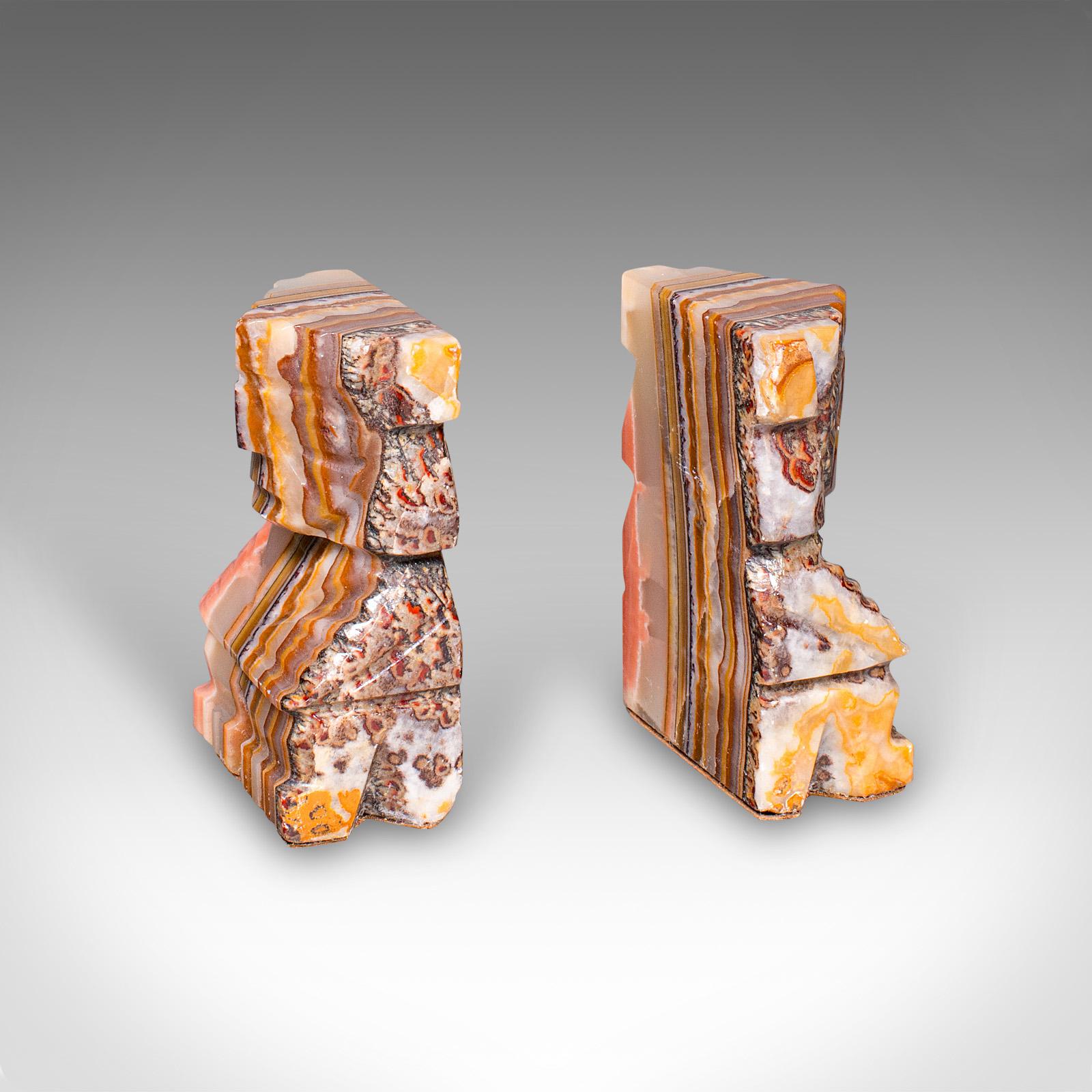 Si tratta di una coppia di fermalibri aztechi vintage. Figura in pietra d'agata a bande intagliata a mano del Sud America, risalente al periodo Art Deco, circa 1930. Il caratteristico intaglio figurato e il superbo colore naturale rendono questi