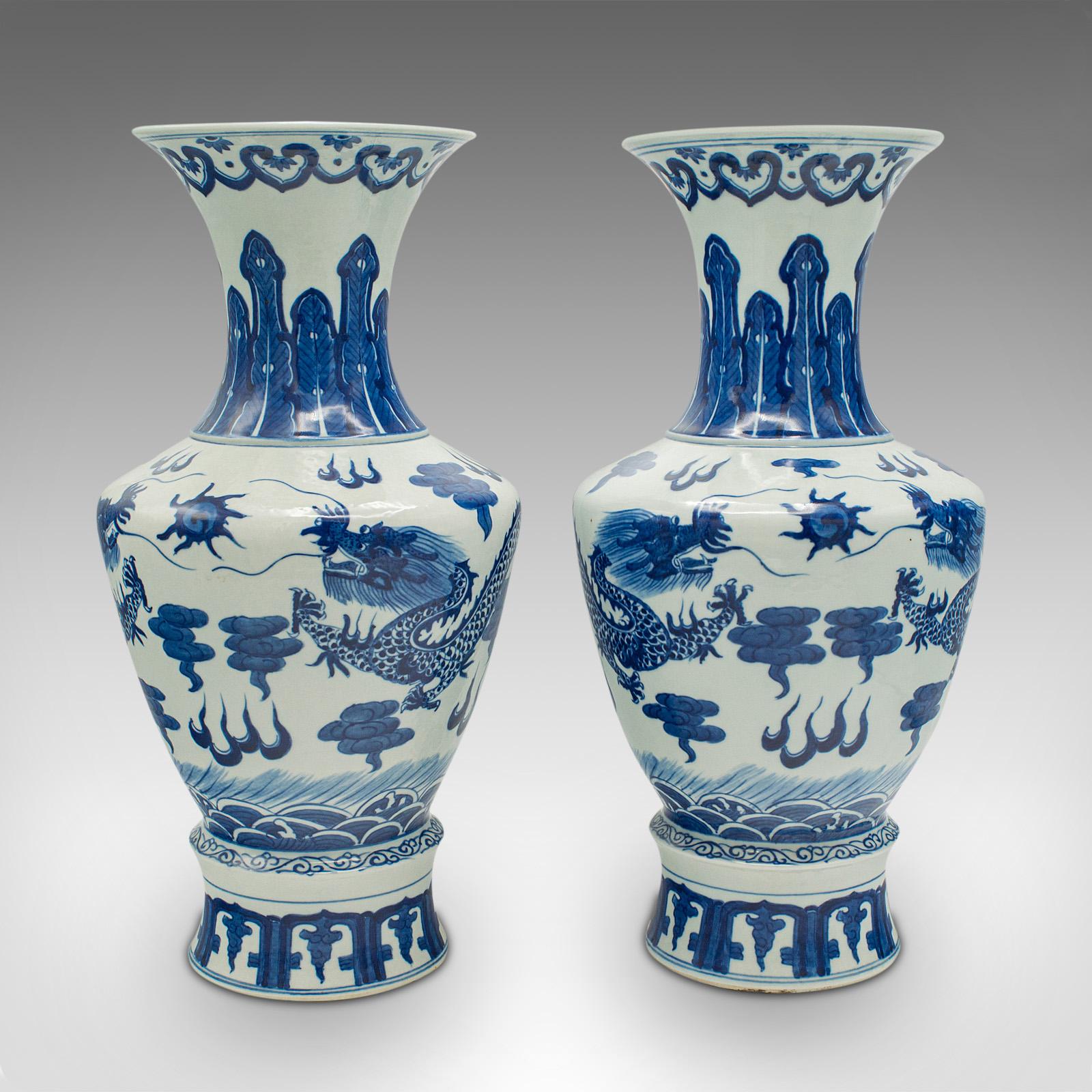 This is a pair of vintage baluster vases. A Chinese, ceramic decorative display urn, dating to the late Art Deco period, circa 1940.

Graced with the iconic white and blue finish
Displaying a desirable aged patina, free of marks or cracks
White
