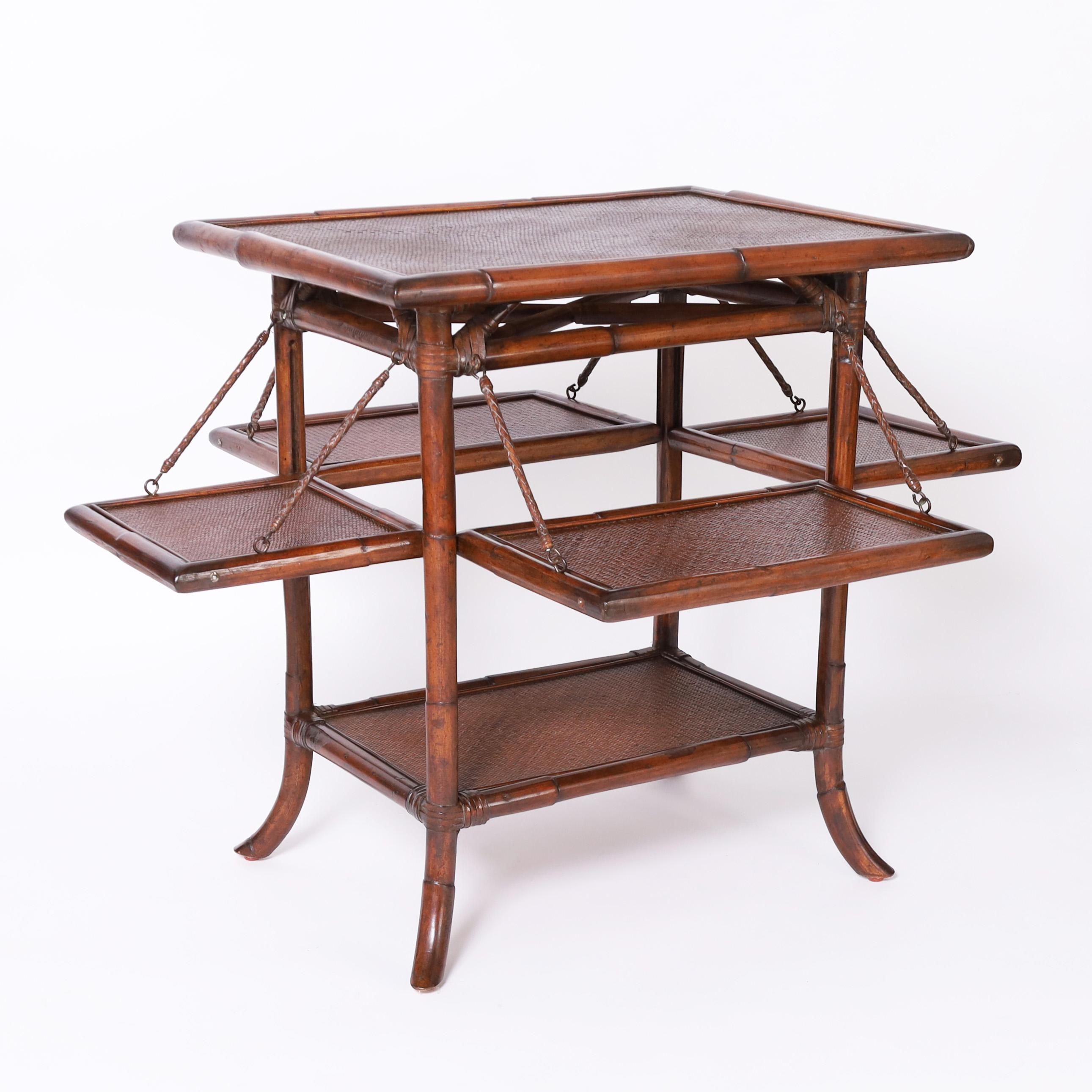 Standout pair of mid century British Colonial style stands or tables crafted with bamboo frames having grasscloth tops and lower tiers with four fold out trays having grasscloth panels uniting form and function.

Measurements with shelves extended: