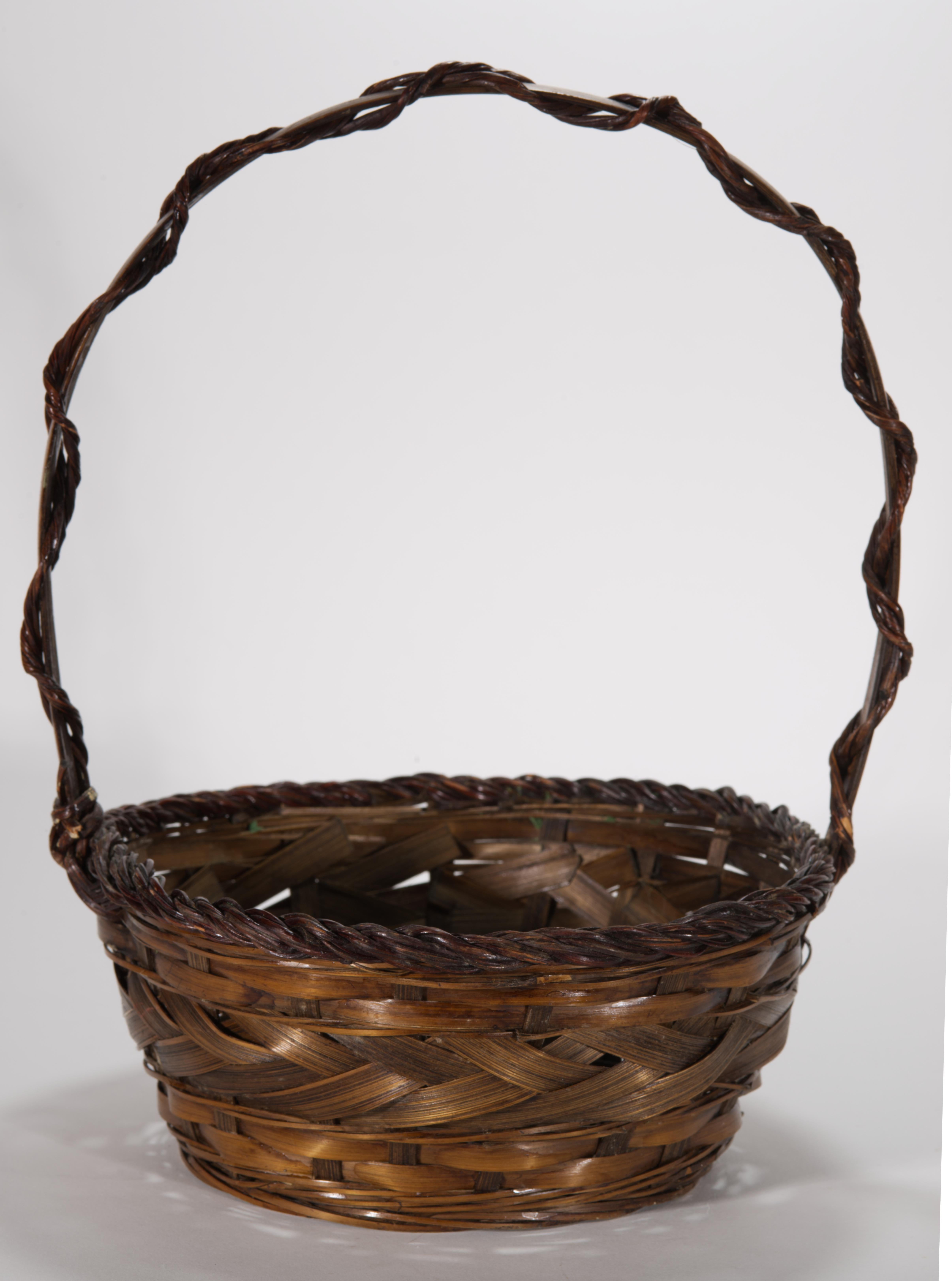 Vintage ikebana flower baskets or hanakago, feature rounded barrel shapes with wide openings, surmounted by high arched handles. The bodies of the baskets are loosely woven with wide and narrow bamboo bands and rattan or wicker, creating a rich