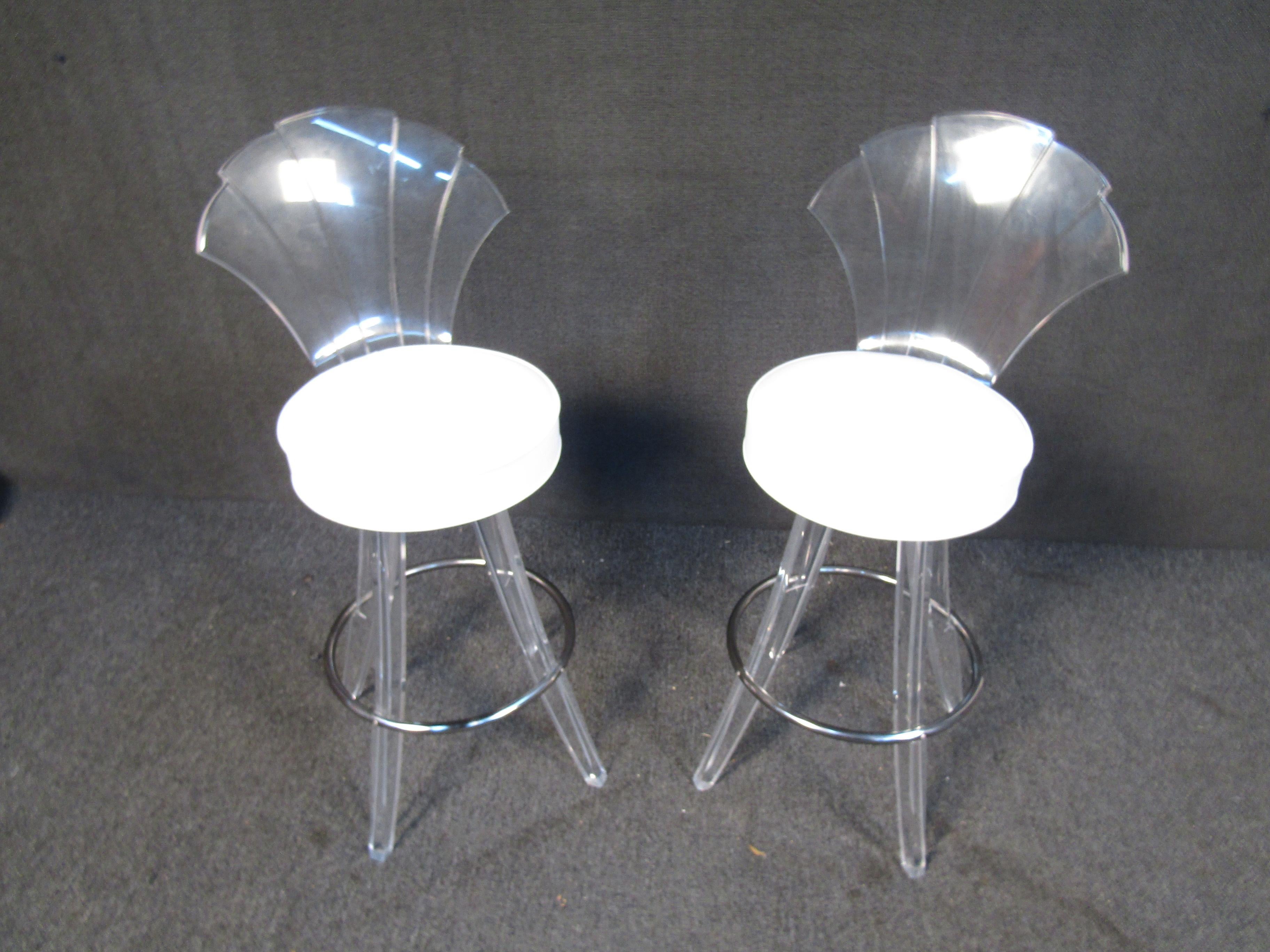 This stunning pair of mid-century bar stools combine lucite frames and backs with white vinyl seats and metal footrests. Please confirm item location with seller (NY/NJ).