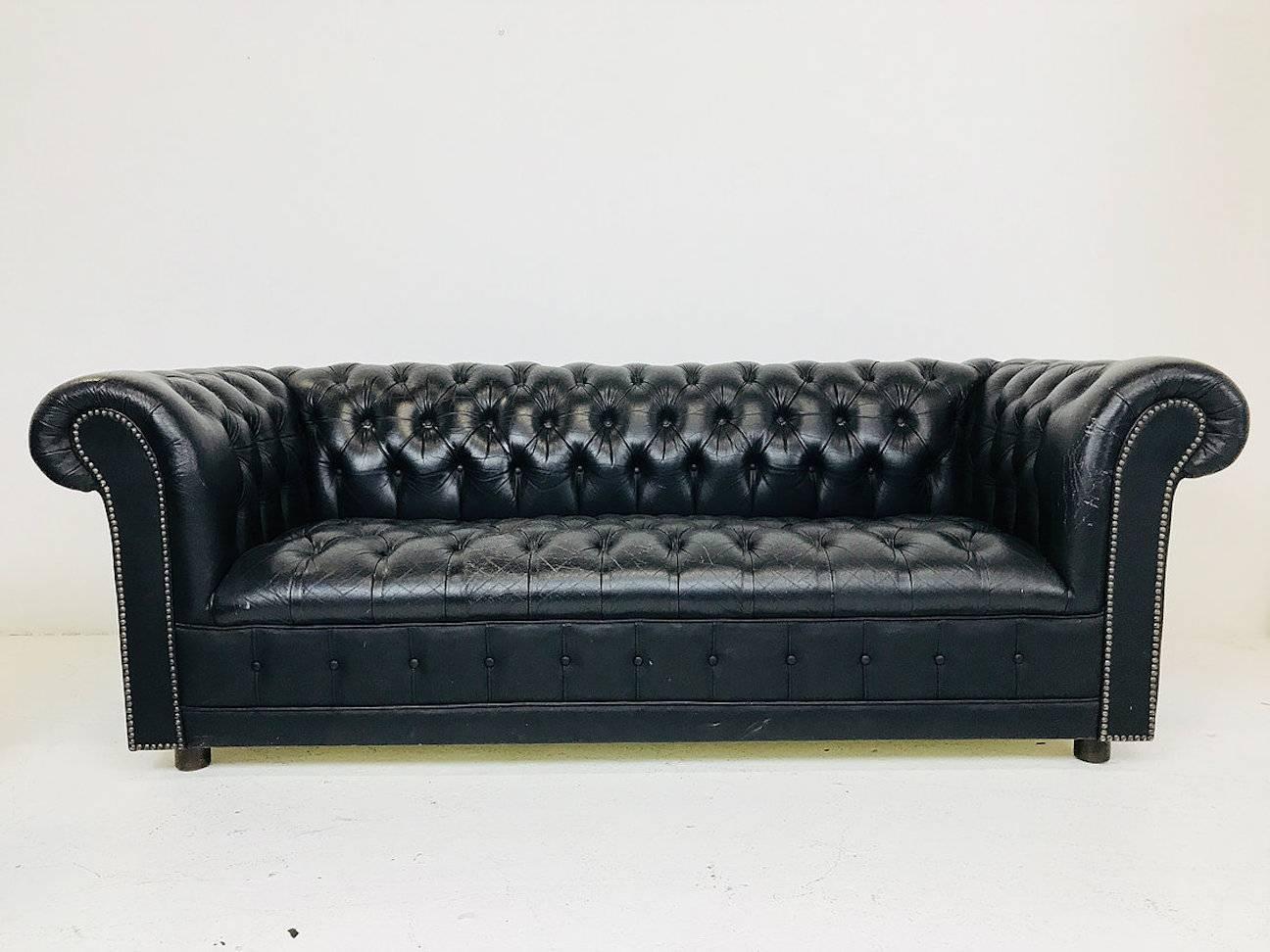 Pair of vintage black leather Chesterfield settees. Leather is worn and has an aged patina. Can be used as is for a aged warm look or have them upholstered for a more modern feel.

Dimensions: 77