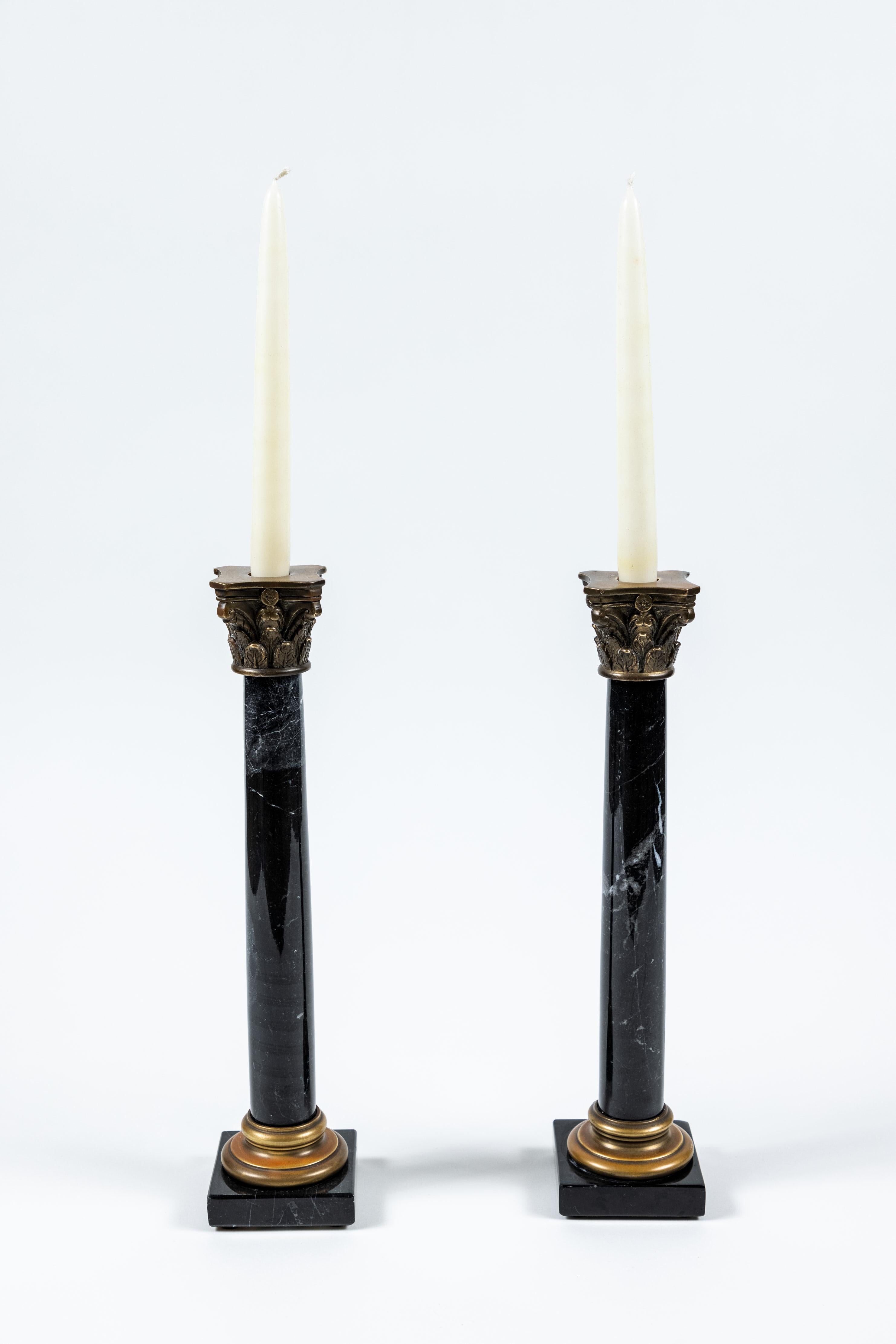 Pair of vintage black marble column candlesticks with bronze band at base and capital on top.