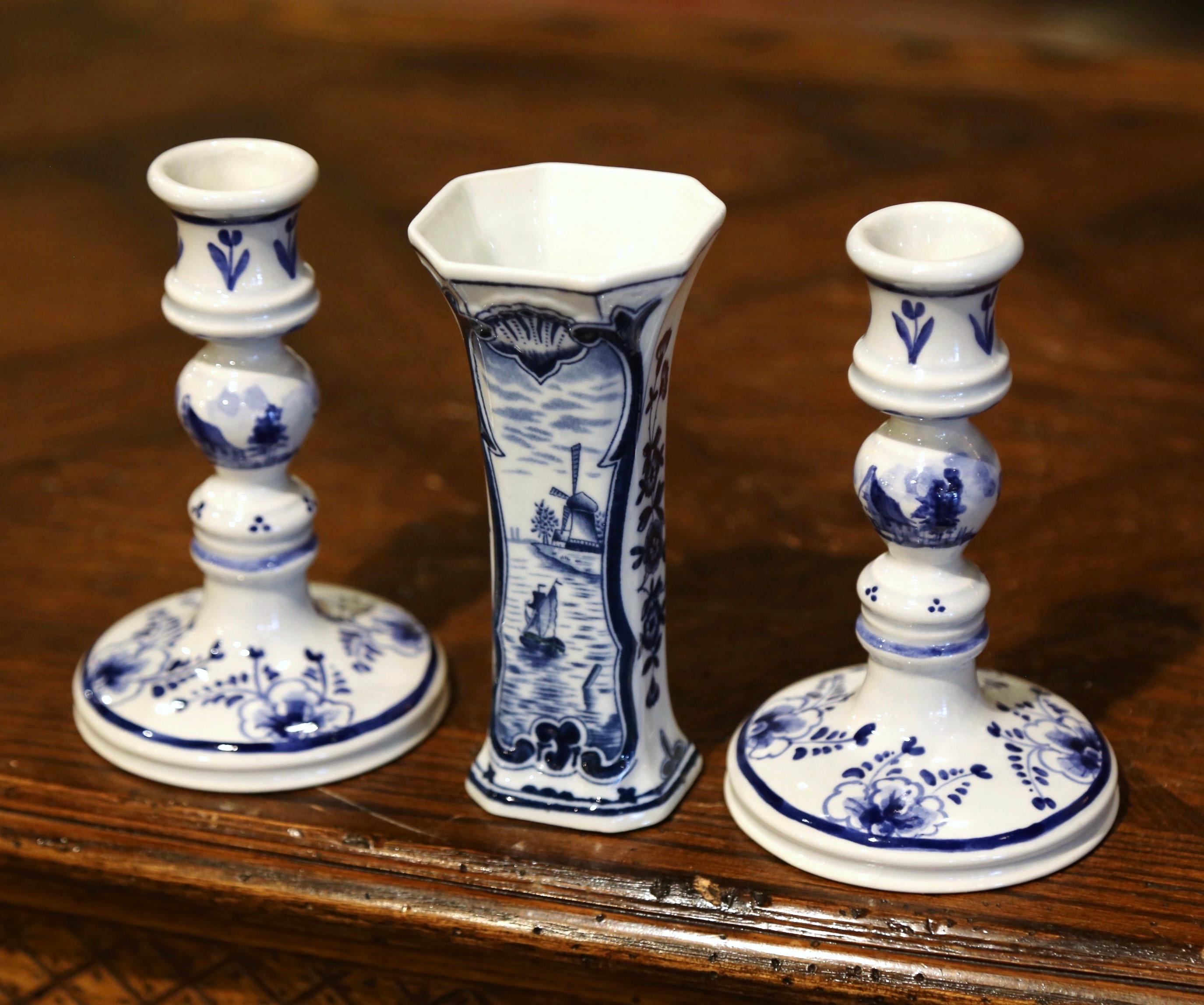Decorate a shelf with this three-piece ceramic set. Crafted in Holland circa 1980, the set includes a pair of candlesticks and vase decorated with floral motifs and embellished with the traditional sailboat and windmill decor. All three pieces are