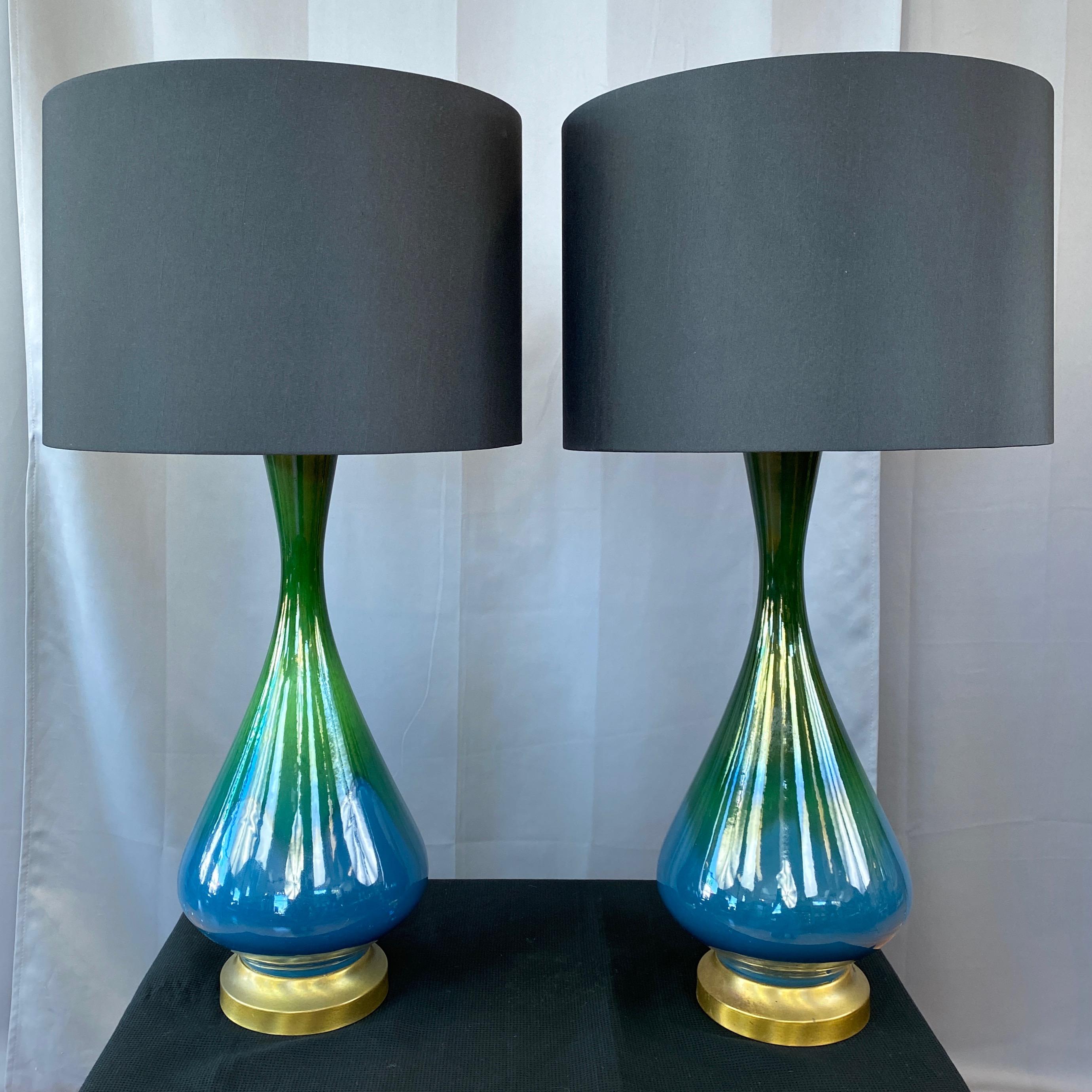 A lovely pair of 1950s blue-green ombré drip glaze ceramic and brass table lamps with black shades.

Perfectly proportioned mid-century modern teardrop body with glossy emerald green glaze transitioning to cerulean blue. On satin finish brass base