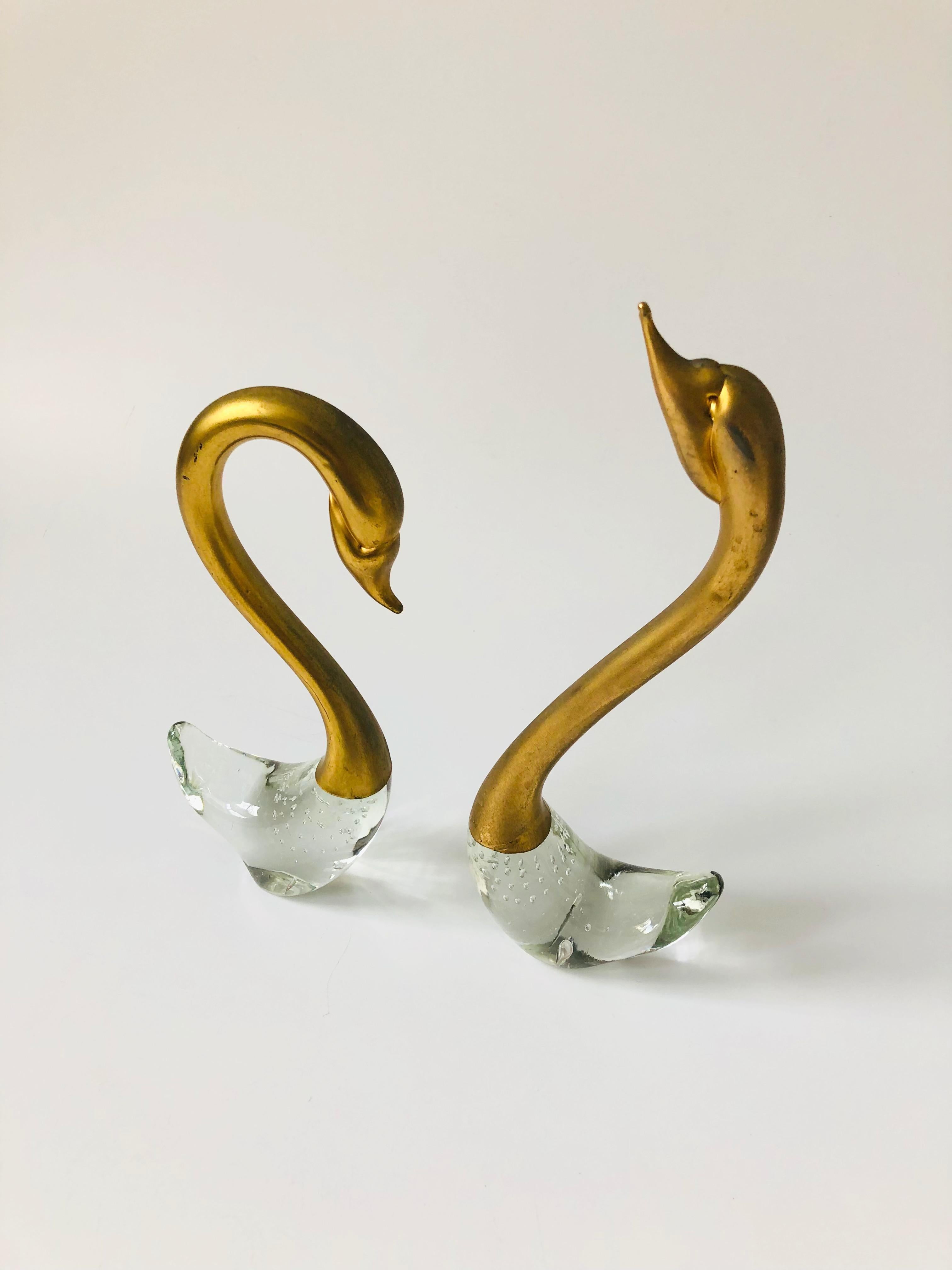 A pair of vintage art glass swans. Beautiful elegant shapes with brass tops and clear bases. Nice controlled bubble detailing to the bases.
The taller swan measures 3.5