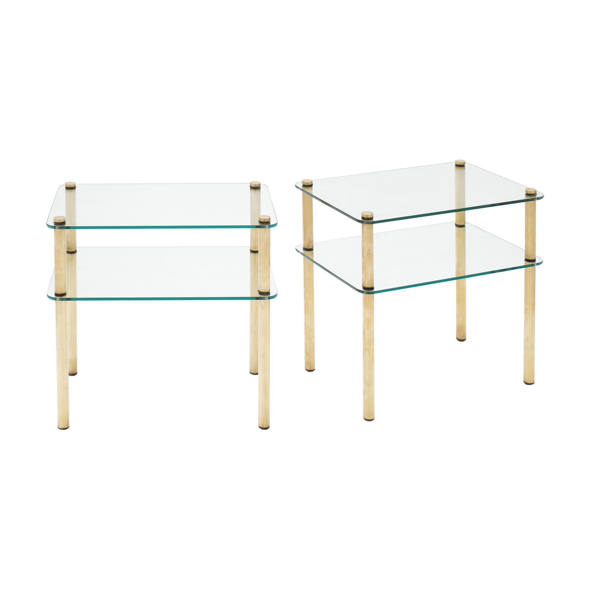 Pair of Italian Mid-Century Modern side tables. Each table features 4 brass tubular legs supporting 2 clear glass shelves.