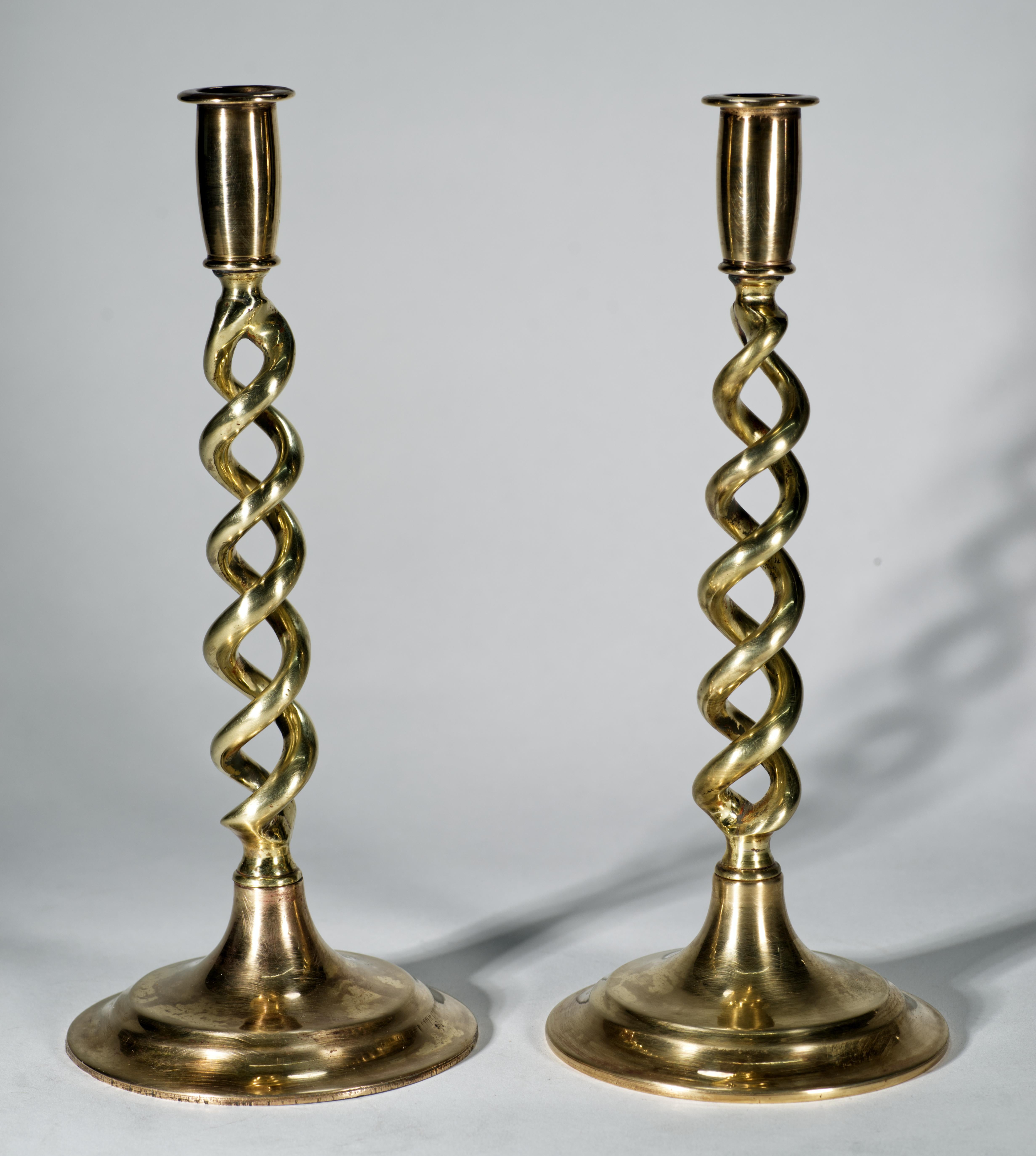  La coppia scultorea di portacandele in ottone antico presenta un design aperto a orzo e basi rotonde a gradini. Il design è una versione del XX secolo dello storico stile Revival Giacobino, molto popolare all'inizio del XX secolo.

I candelieri