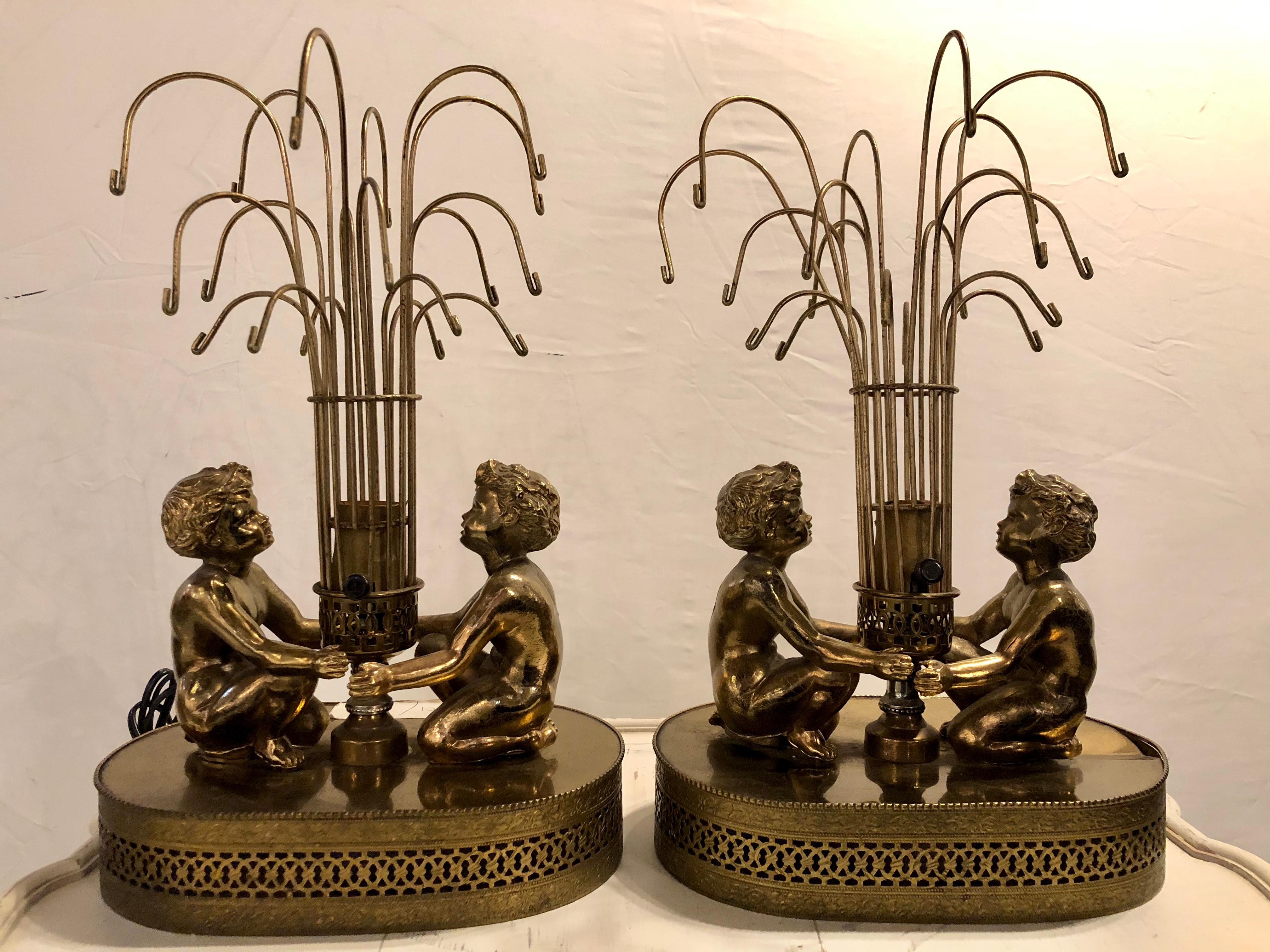 Pair of vintage brass double cherub table lamps. Fine decorative table lamps each having a center light formed as a fountain with opposing cherubs facing and looking at the waterfall.