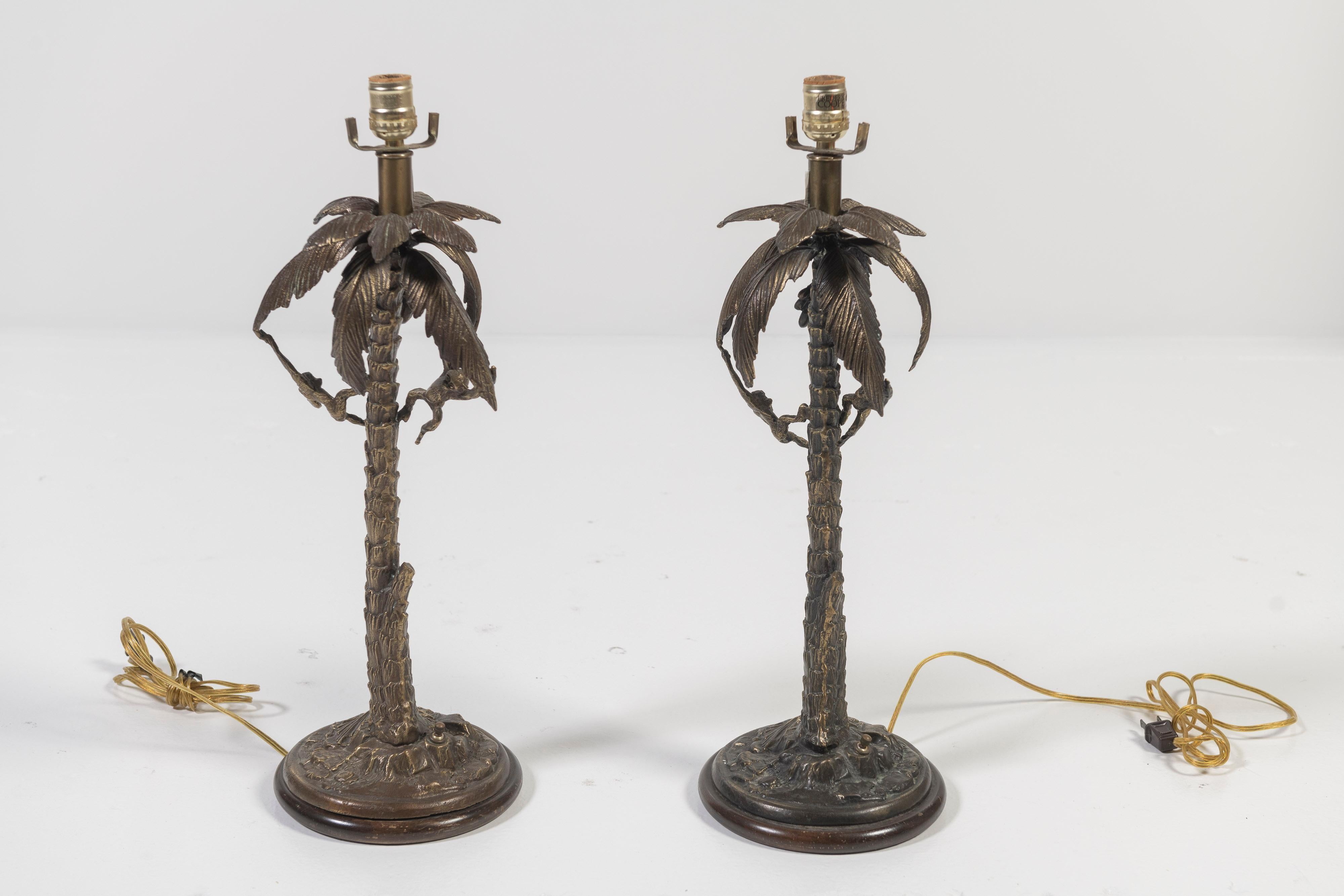 Pair of collectible vintage Frederick Cooper brass lamps of palm trees with hanging monkeys are enchanting and in great condition. Between mid-century modern, British Colonial and Caribbean styles, this pair is artistic and define casual hospitality