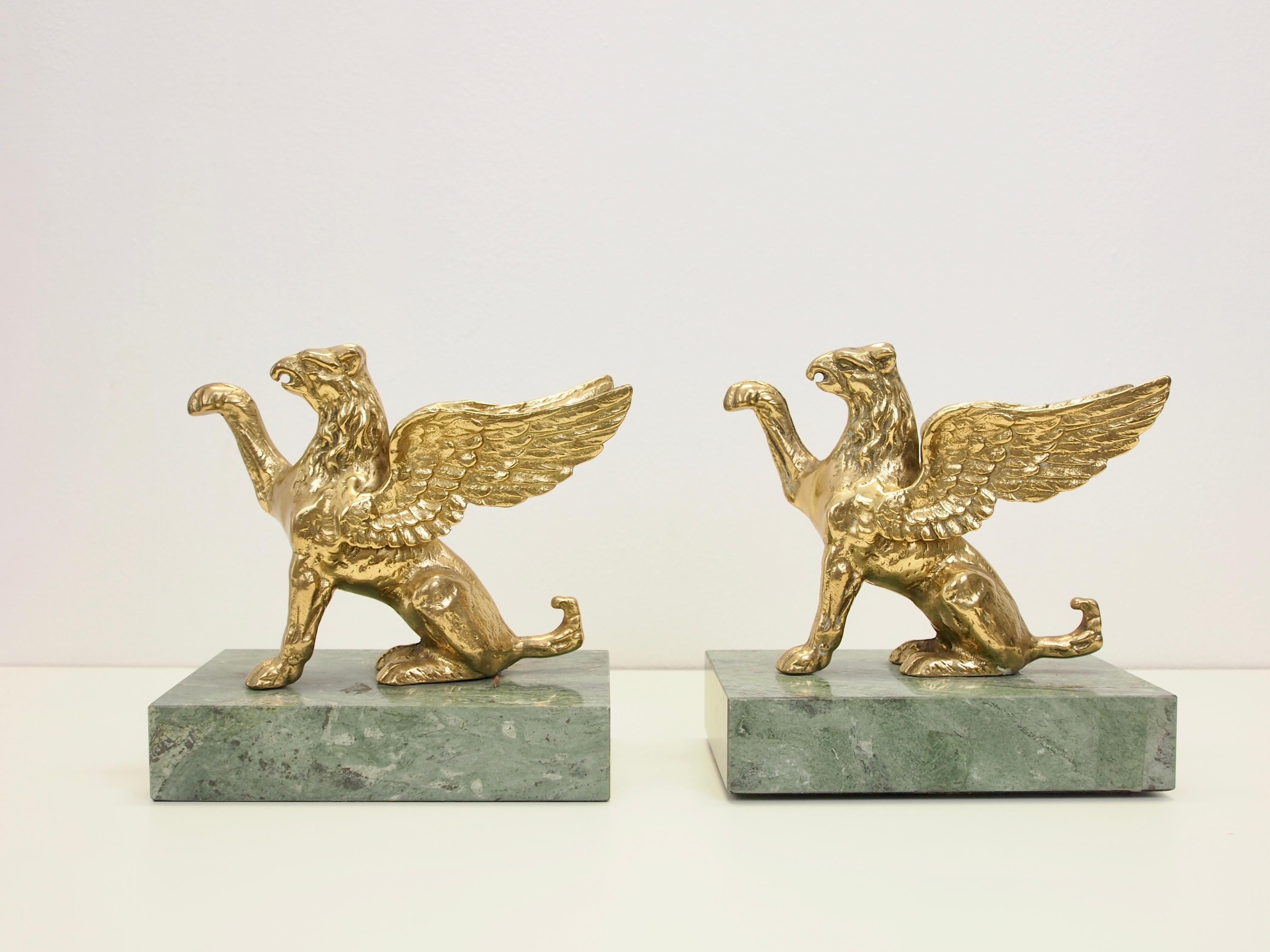 Stunning pair of 2 vintage brass figurines in the shape of 2 griffins on green marble pedestals.

The griffin (or griffon) is a legendary creature with the body, tail, and back legs of a lion; the head and wings of an eagle; and sometimes an