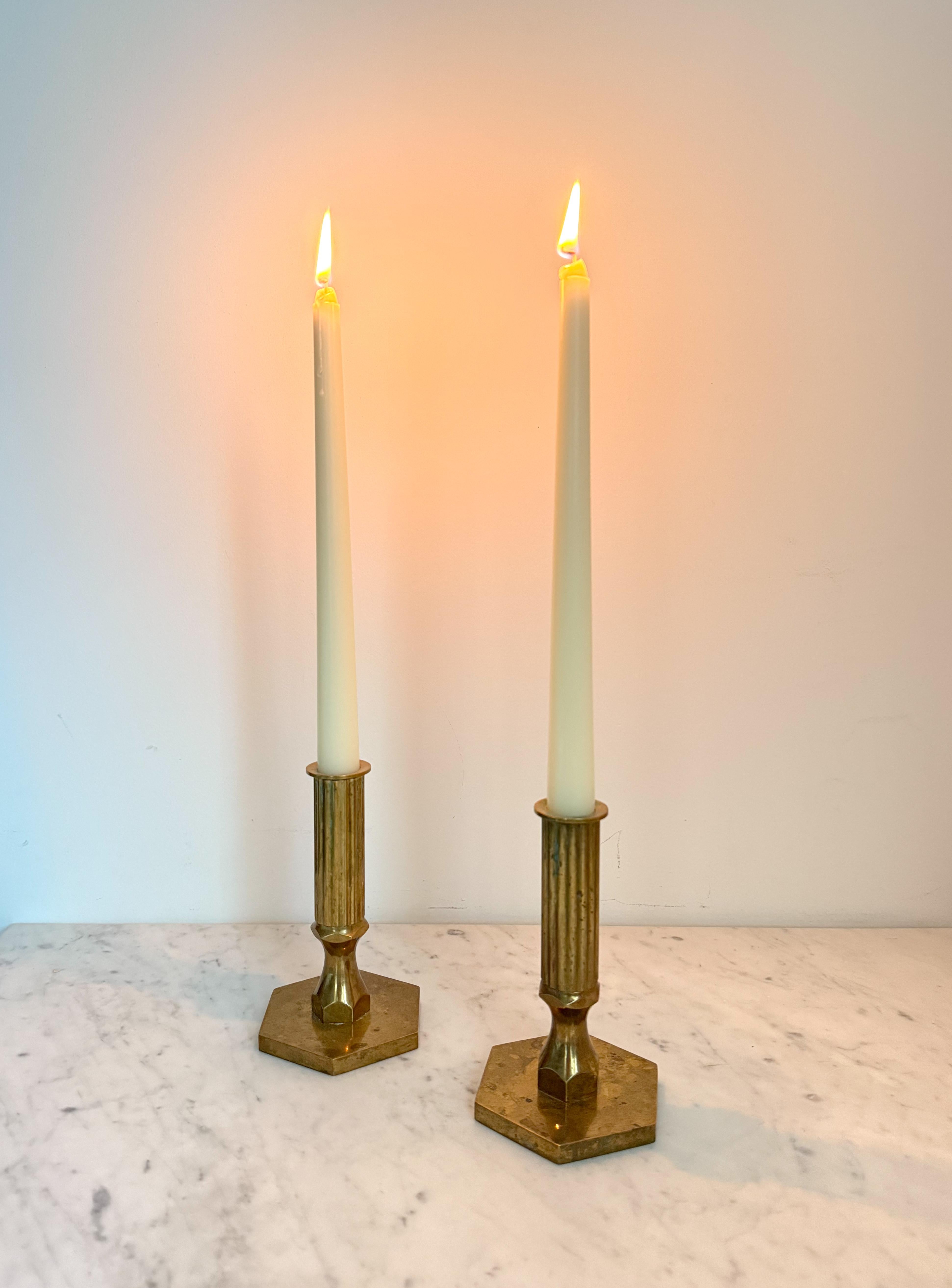 A pair of solid brass candlesticks by Metallslöjden Gusum Bruk, Sweden.  Designed by Bernt Karlsson.  Dated 1978 and 1980.
